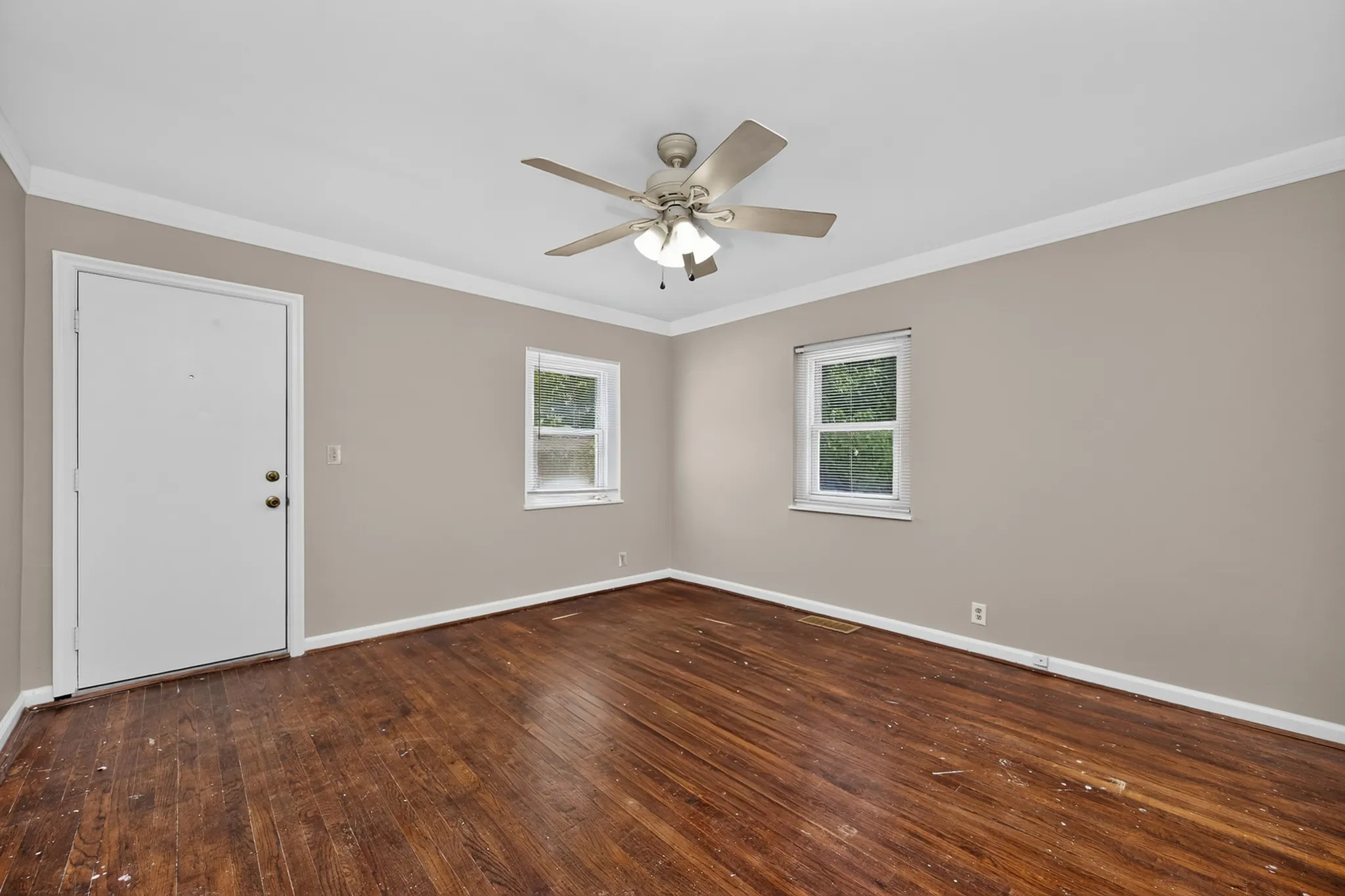 Inviting room with elegant hardwood floors, neutral walls, and abundant natural light, perfect for a cozy living space.