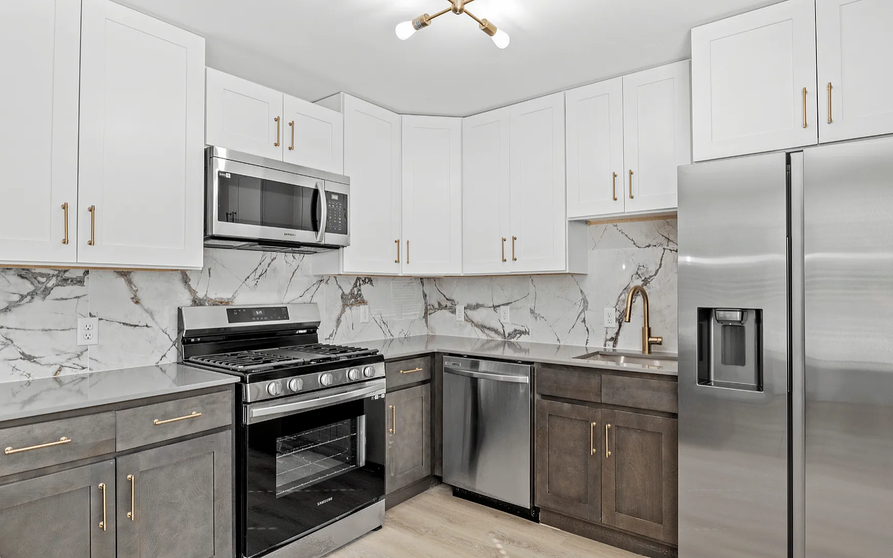 Modern kitchen with sleek stainless steel appliances, elegant marble backsplash, and stylish dual-tone cabinetry.