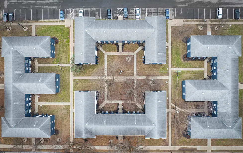Aerial view of modern apartment complex with distinctive geometric layout, landscaped grounds, and ample parking spaces.  Pet-Friendly Apartments in Newport, KY.