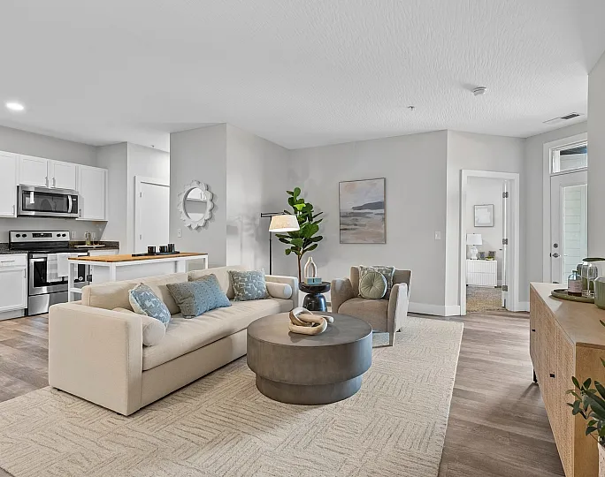 Inviting open-concept living room with modern kitchen, stylish decor, and natural light.