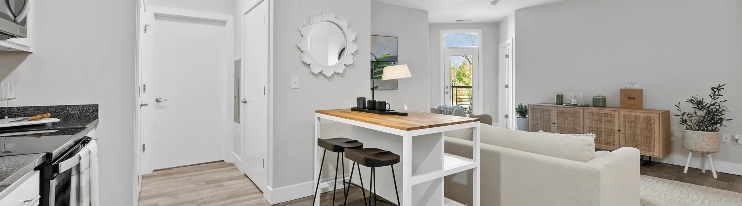 Bright open-concept apartment with modern kitchen, island seating, and cozy living area.