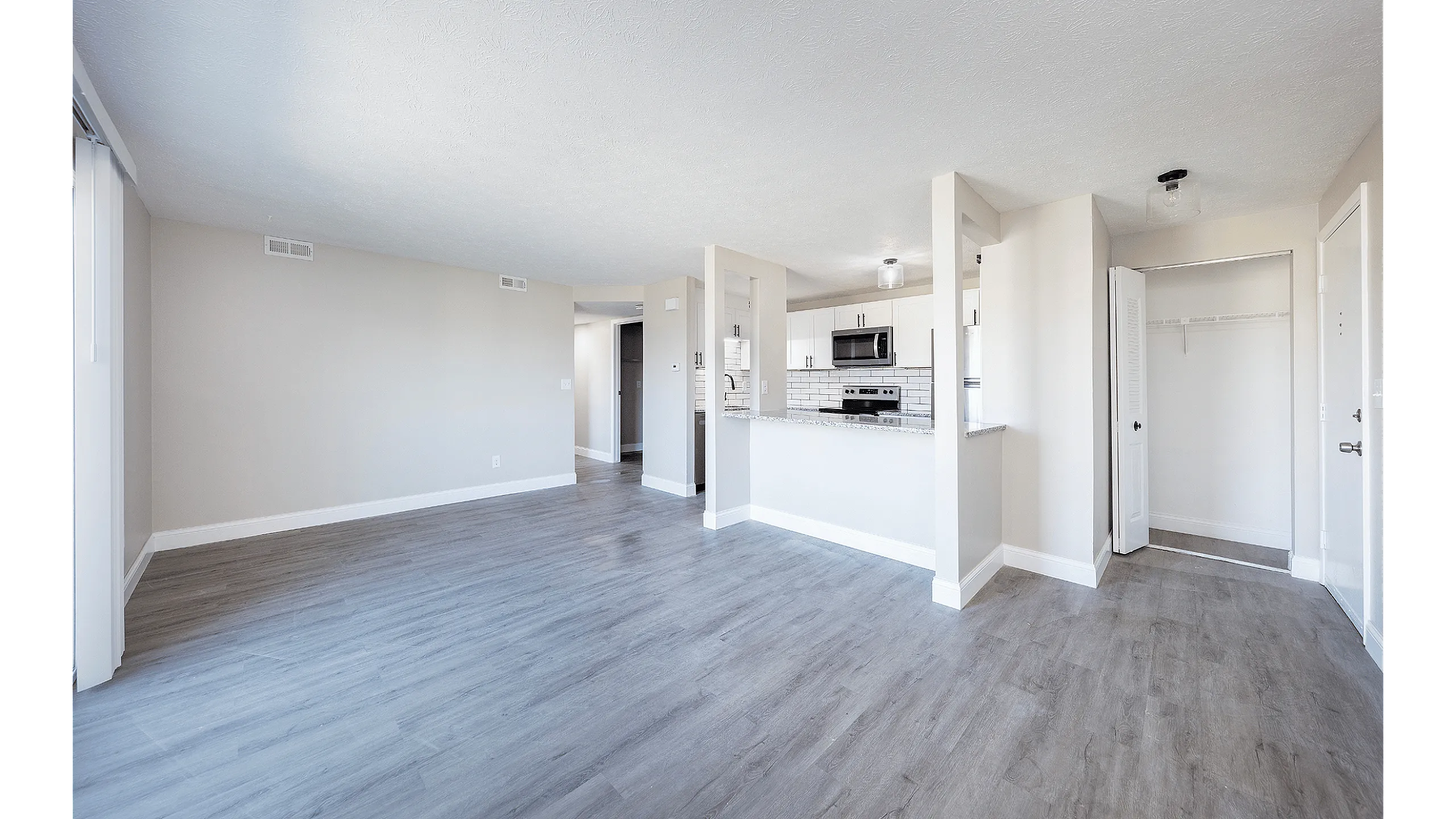 Fairfield Square Apartments Renovated Kitchen and Living Room, Spacious modern apartment featuring open-plan layout with sleek kitchen, large living area, and stylish wood floors.