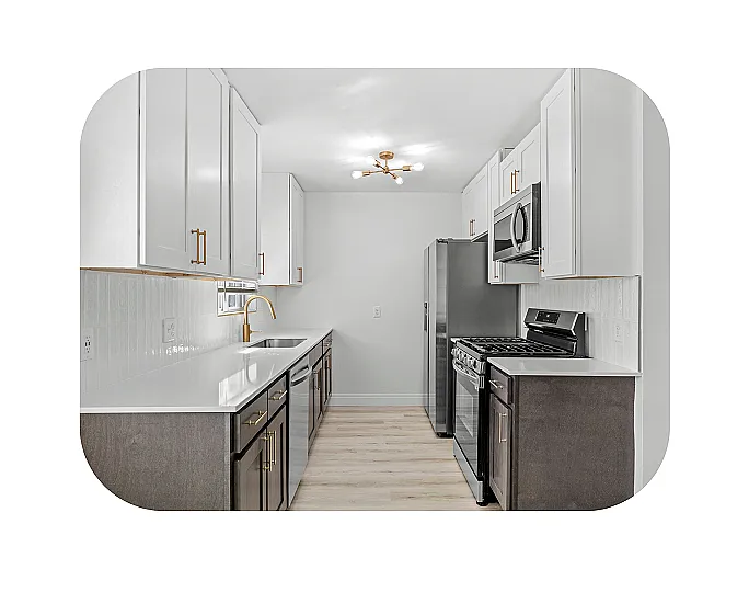 Modern kitchen with sleek white cabinetry, stainless steel appliances, and elegant gold fixtures. Apartments for rent in Newport, KY. Cadence of Newport apartments.