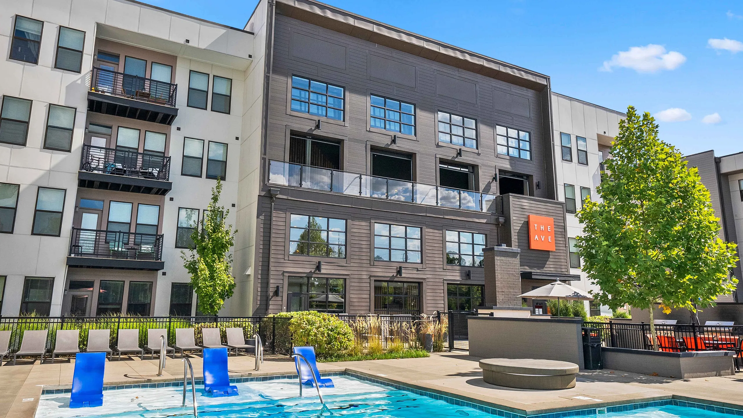 Outdoor swimming pool with lounge seating at The Ave Apartments in Clintonville, Columbus, OH offering a relaxing resort-style atmosphere.