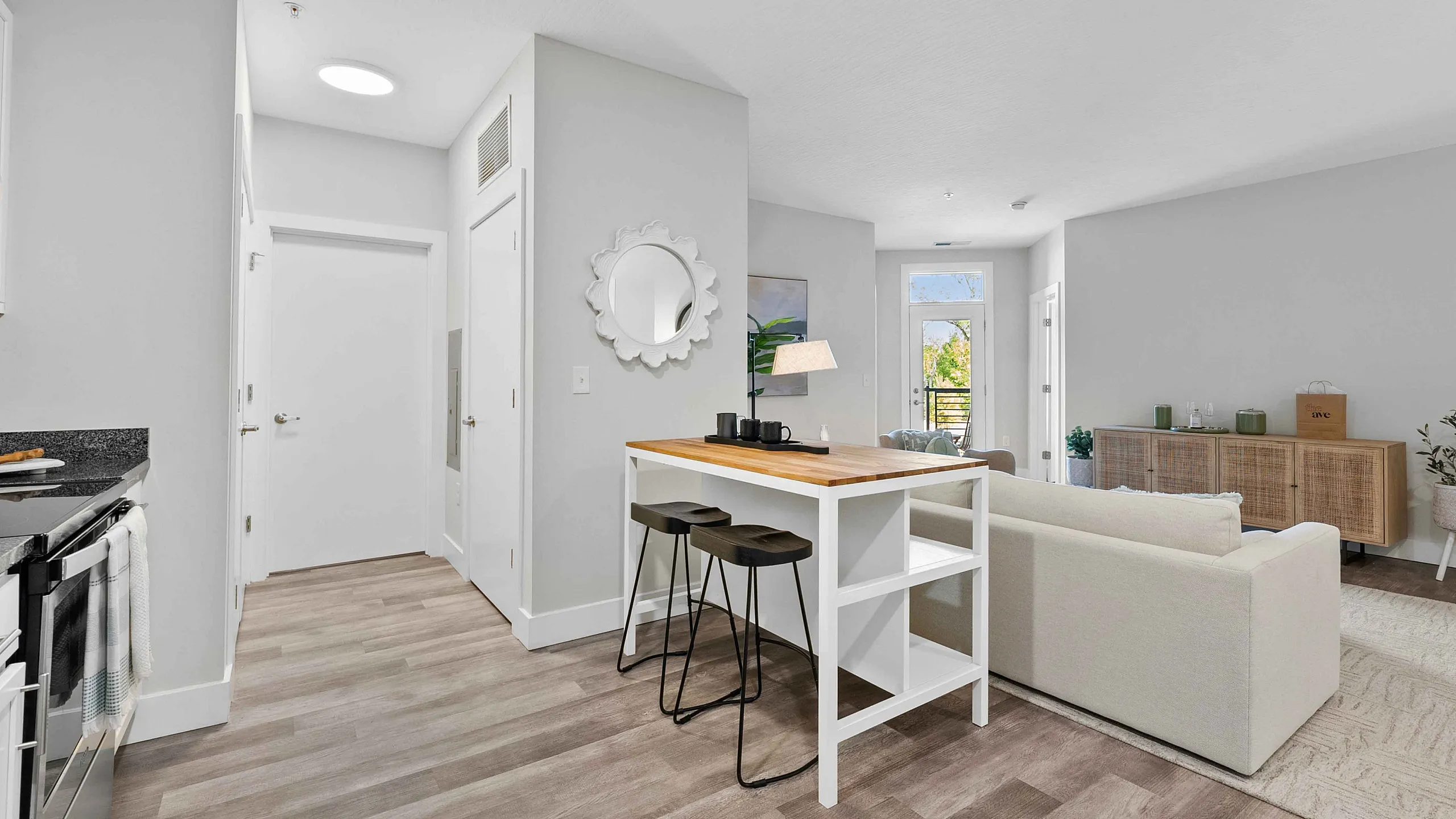 Bright model apartment living room at The Ave in Clintonville, Columbus, OH with open-concept design, wood-style floors, and modern furniture.