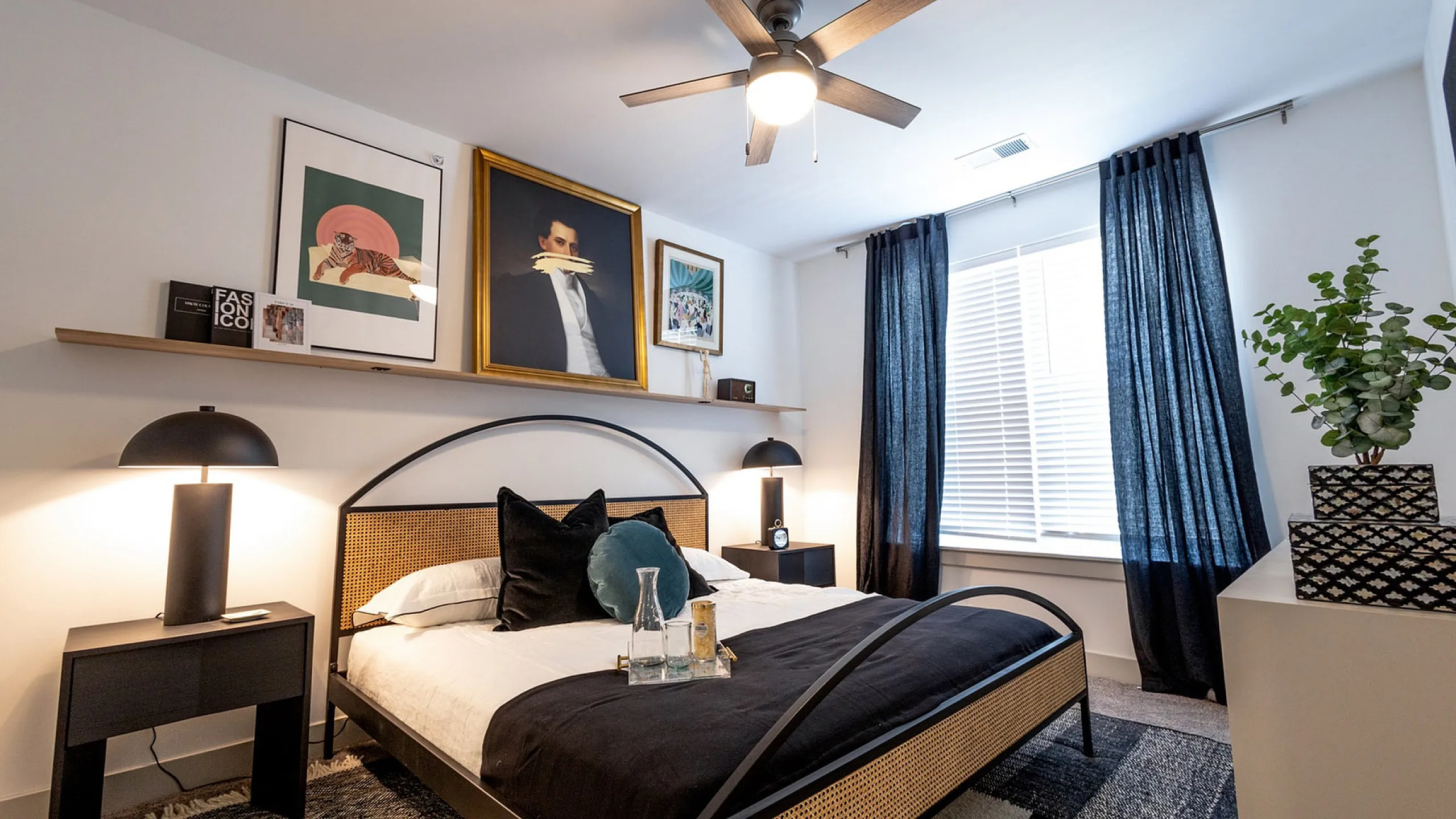 Inviting bedroom with a modern design featuring stylish artwork, elegant lighting, and a cozy bed with plush pillows.