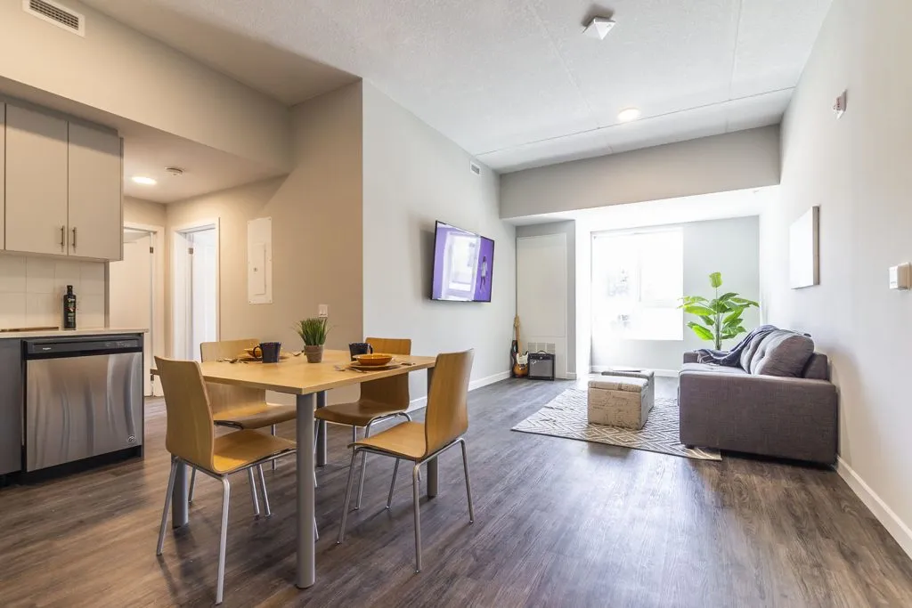 Modern open-concept living space with sleek kitchen, elegant dining area, and cozy lounge featuring natural light and stylish decor.