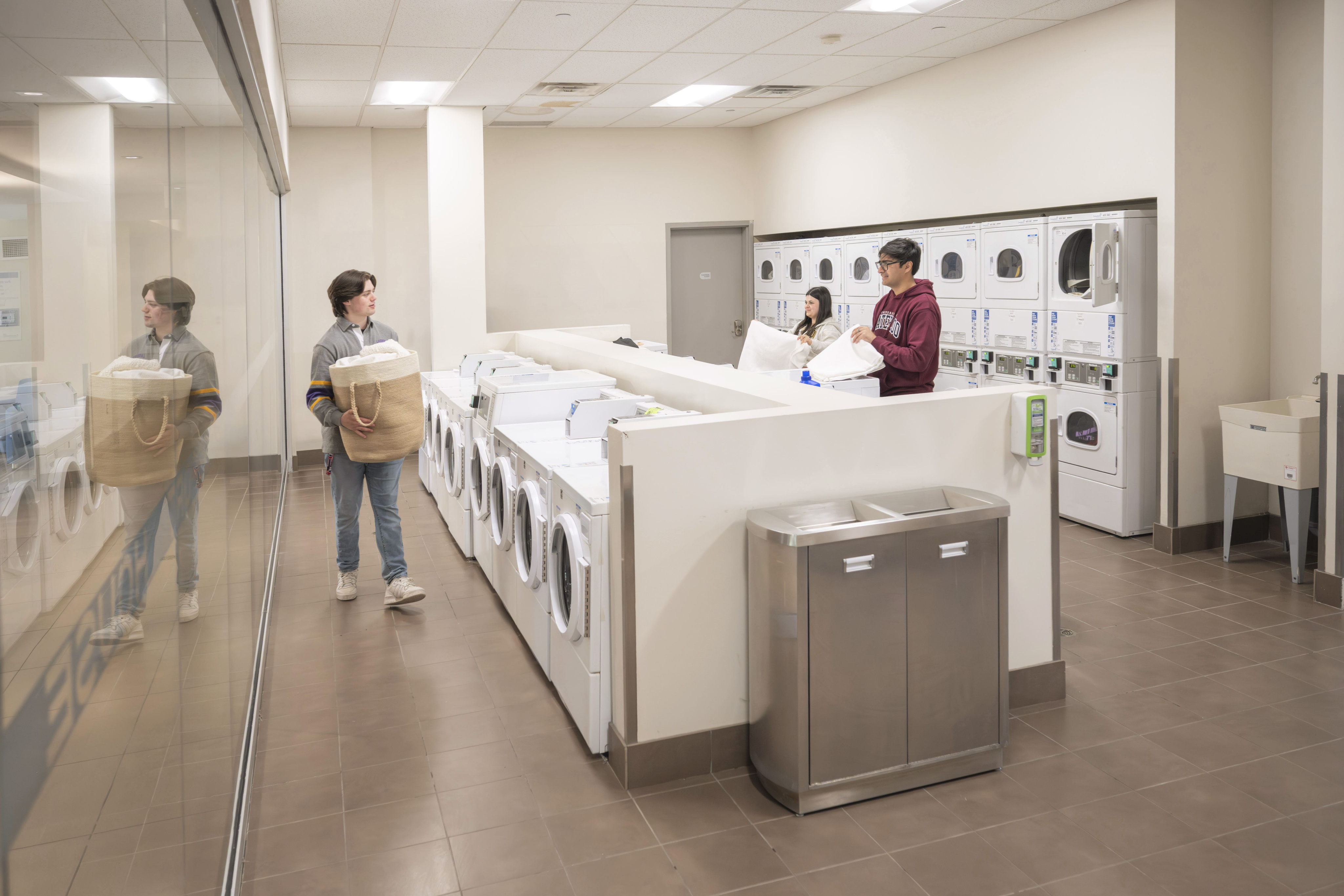 Modern laundry room with high-efficiency washers and dryers, featuring a clean and bright design, perfect for convenient living.