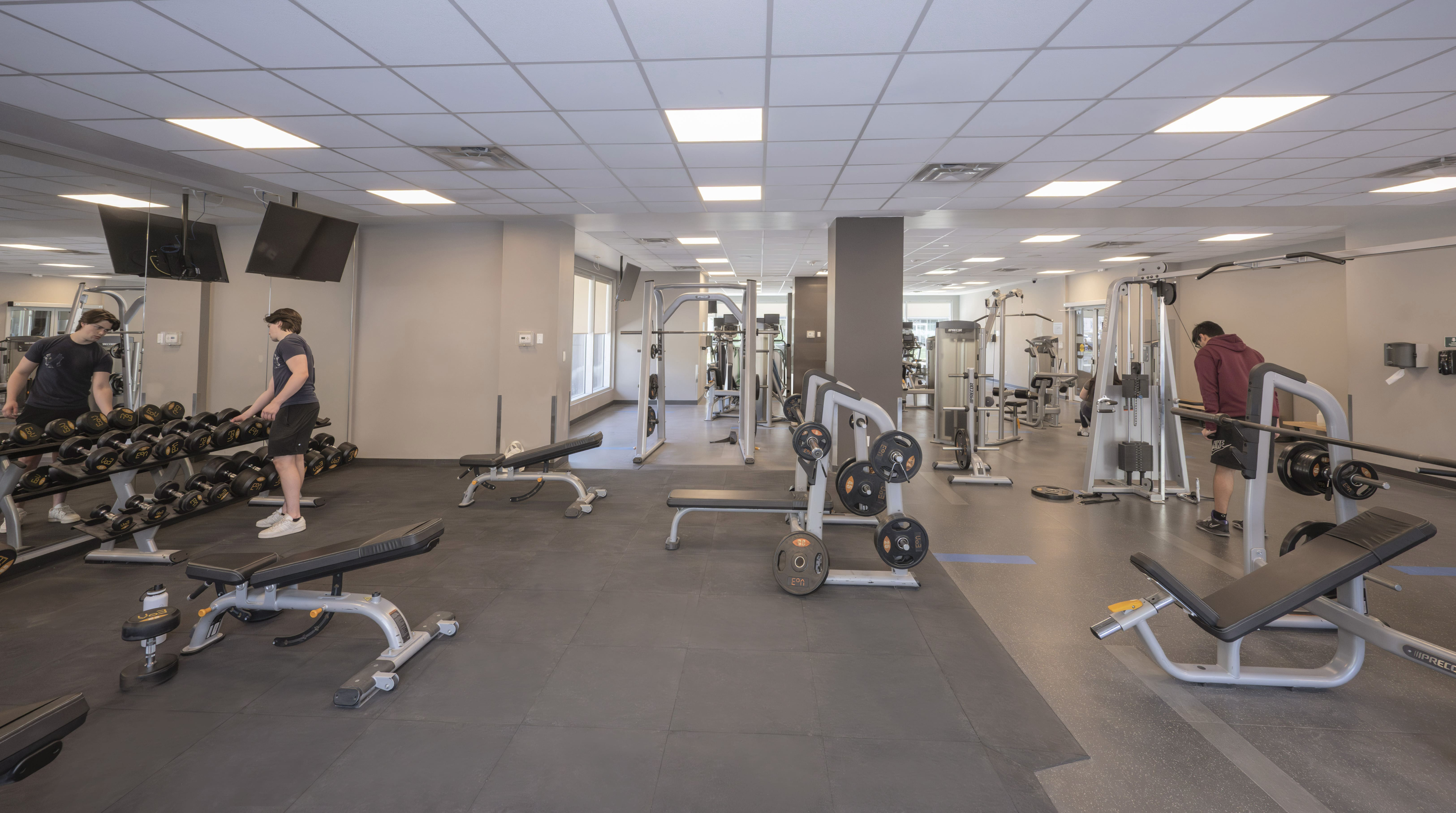 Modern fitness center equipped with state-of-the-art equipment, free weights, and spacious workout areas.