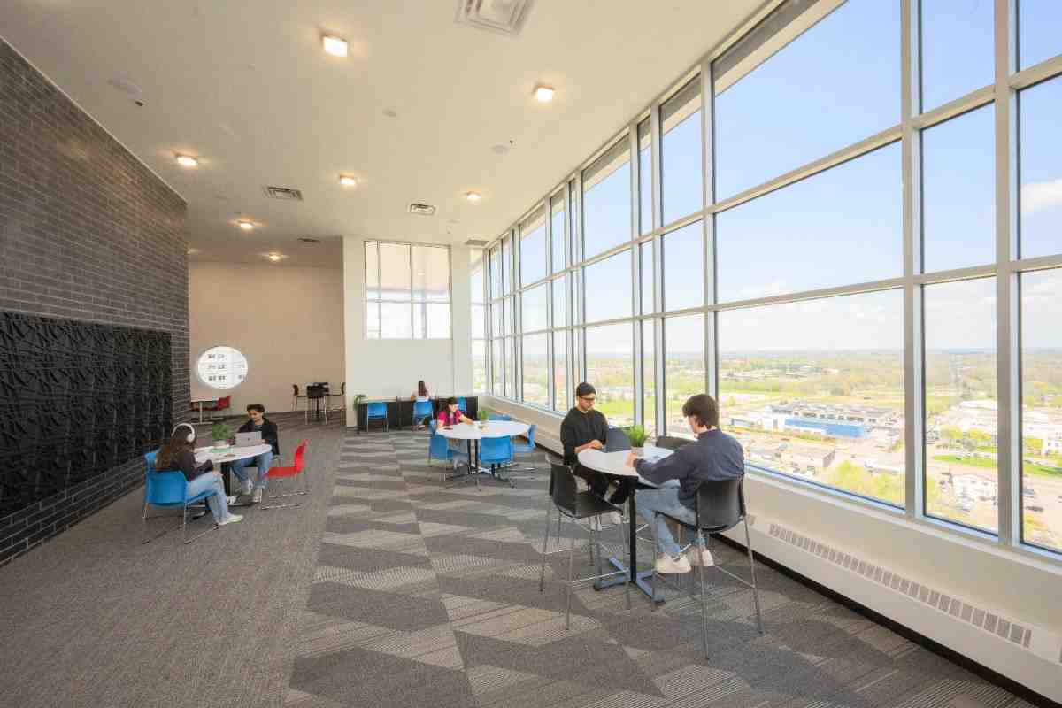 Spacious lounge area with floor-to-ceiling windows offering stunning cityscape views, modern seating, and plenty of natural light.