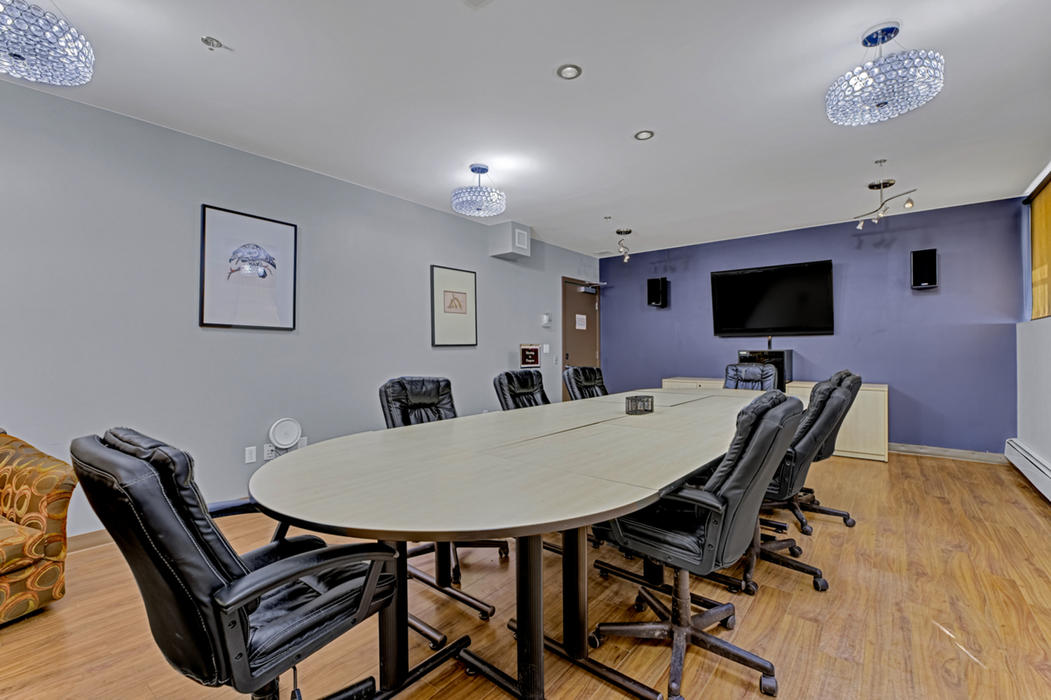Sophisticated conference room with modern decor, featuring a large oval table, plush leather chairs, and elegant lighting fixtures.