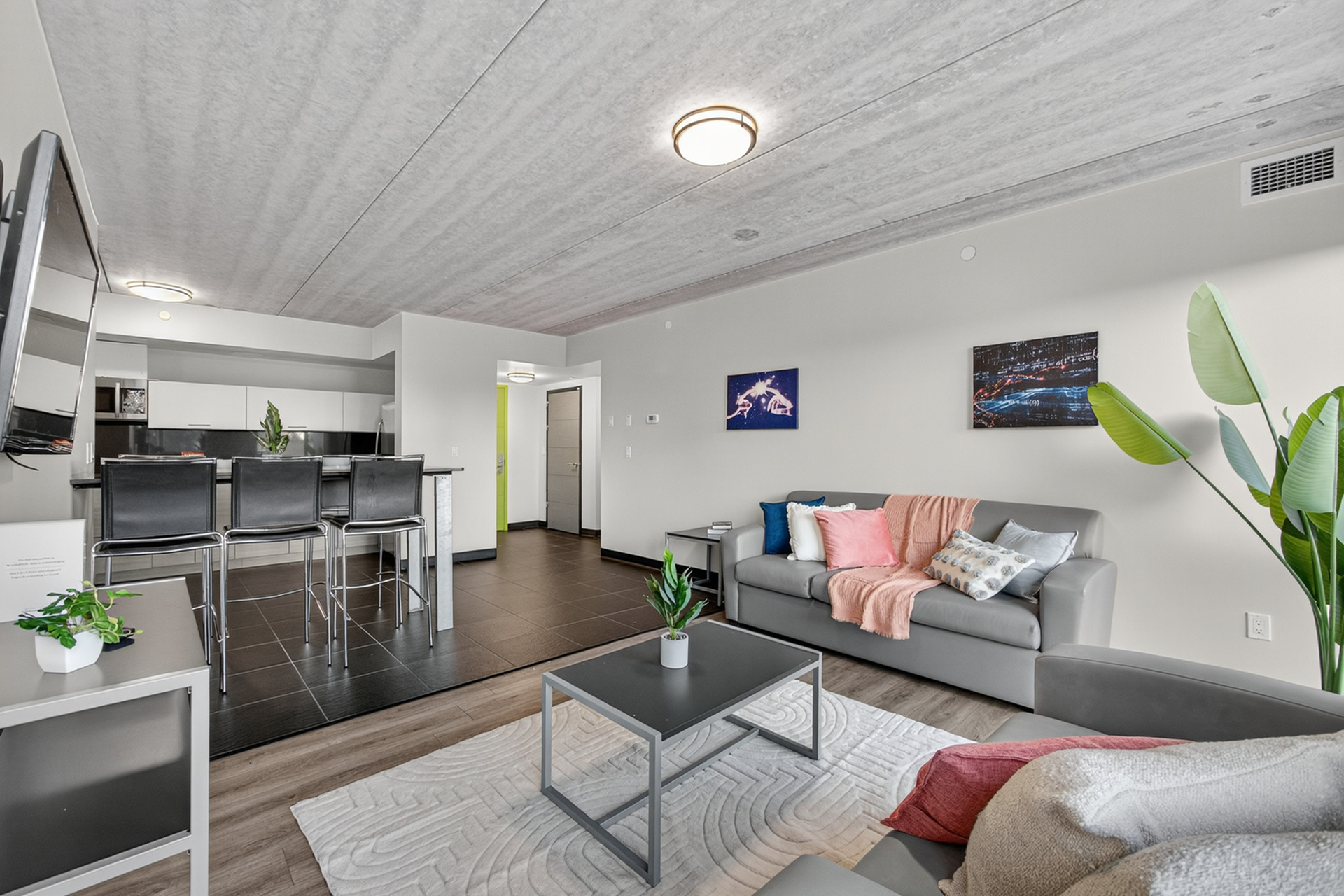 Modern open-concept living room and kitchen with stylish decor, calming palette, and sleek furniture in a chic apartment setting.