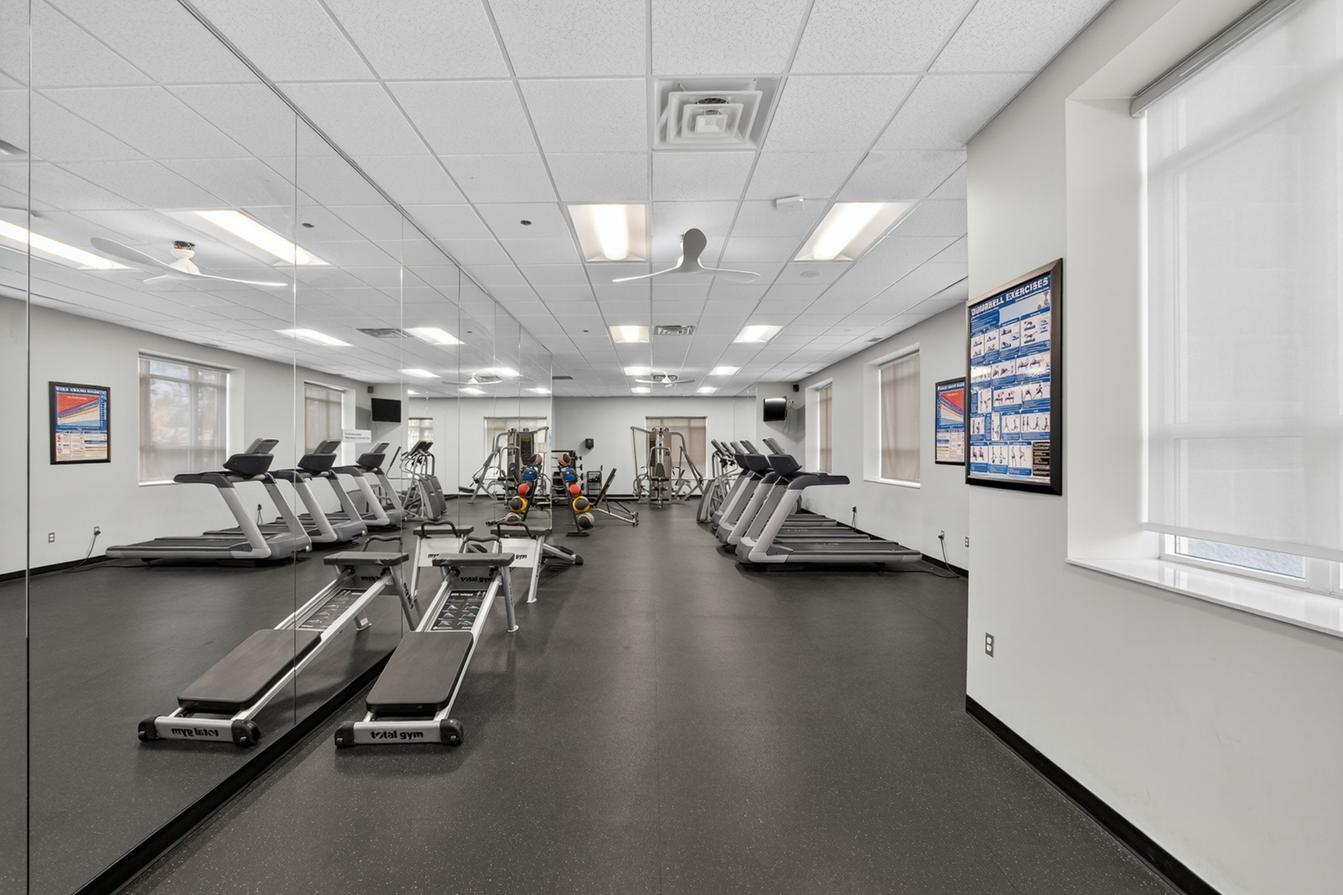 Modern fitness center with state-of-the-art treadmills, mirrored walls, and a range of exercise equipment for a dynamic workout experience.