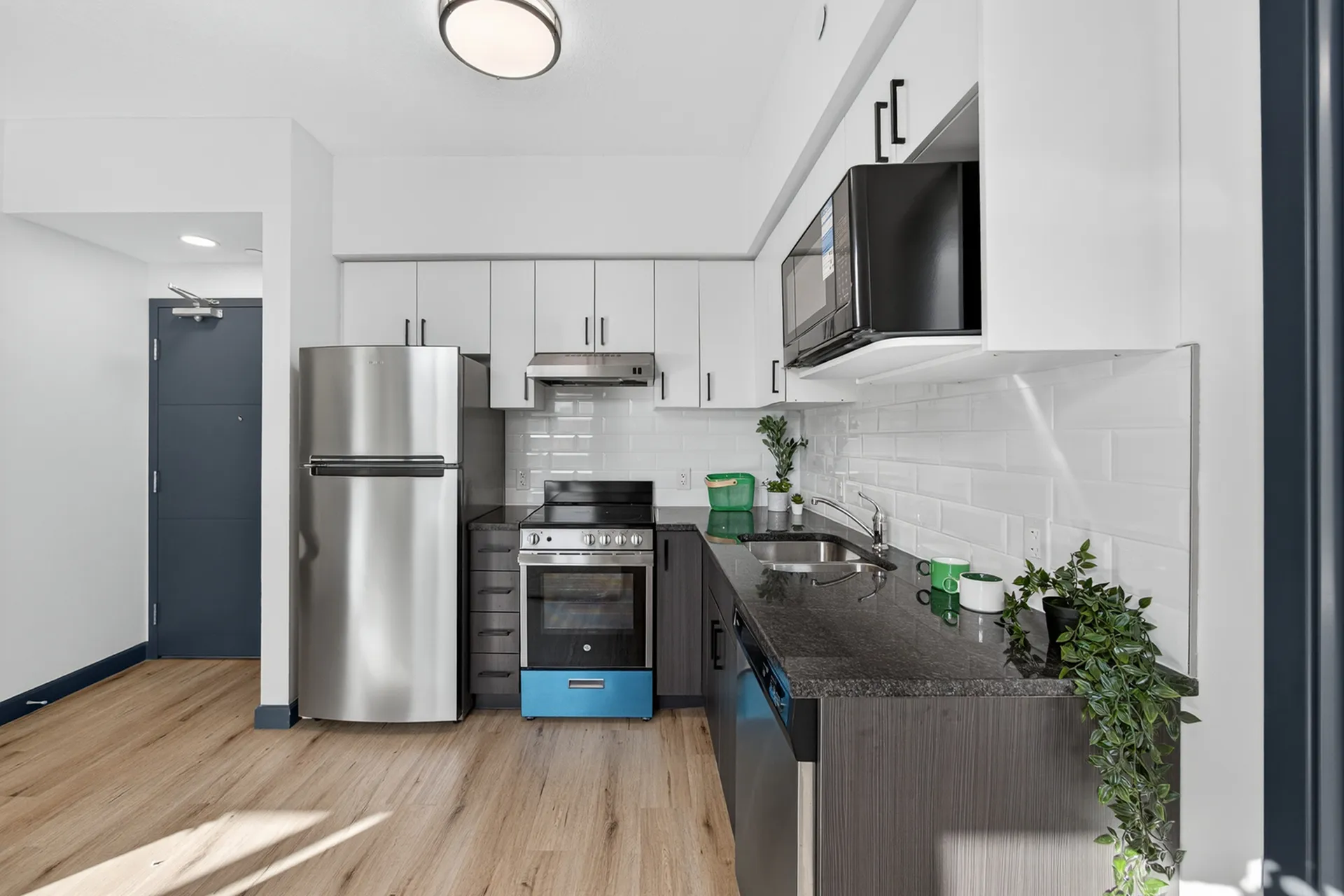 Modern kitchen with sleek stainless steel appliances, elegant cabinetry, and bright wood flooring, perfect for culinary enthusiasts.