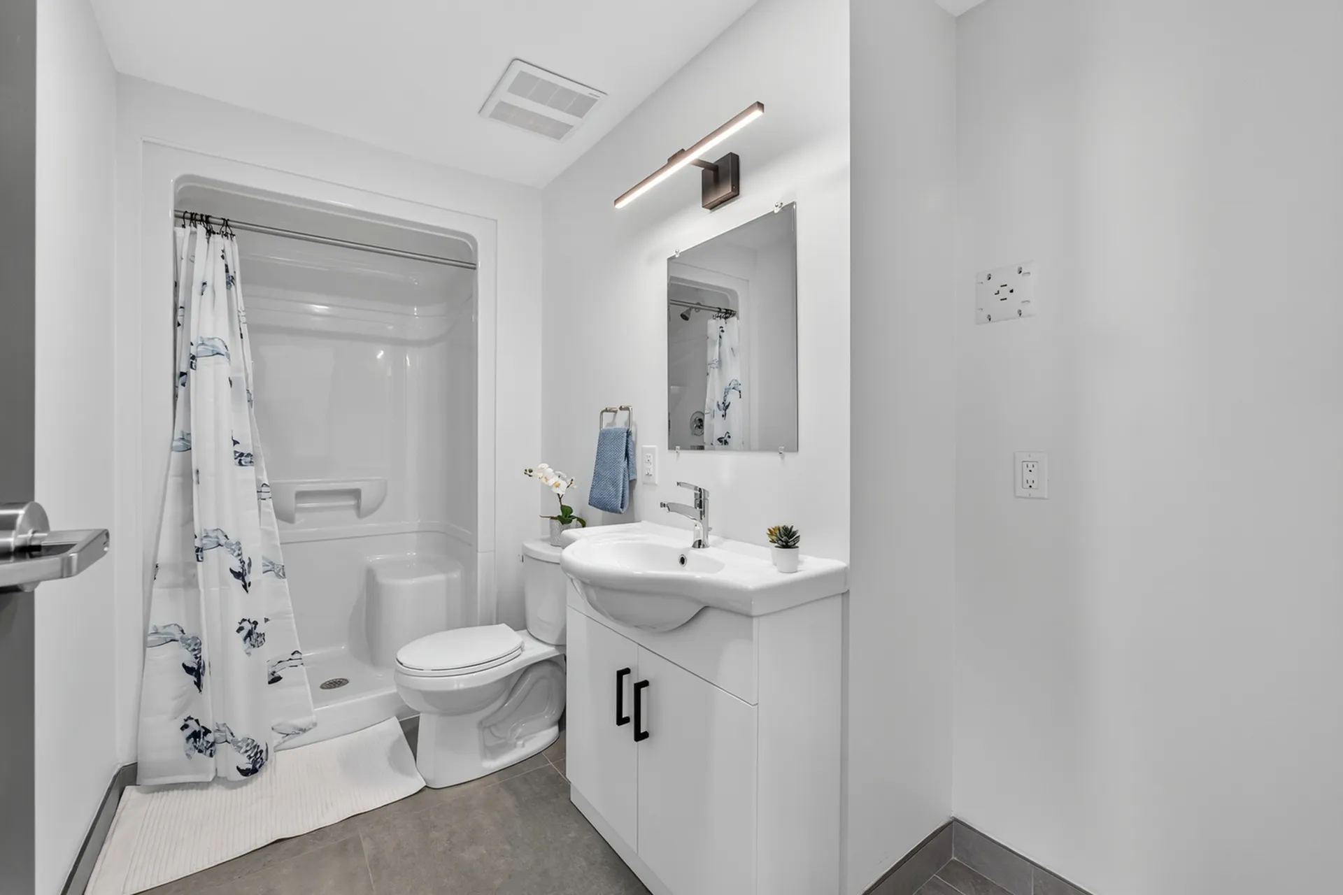 Modern bathroom with sleek fixtures, elegant vanity, and a pristine shower area, perfect for relaxation and comfort.
