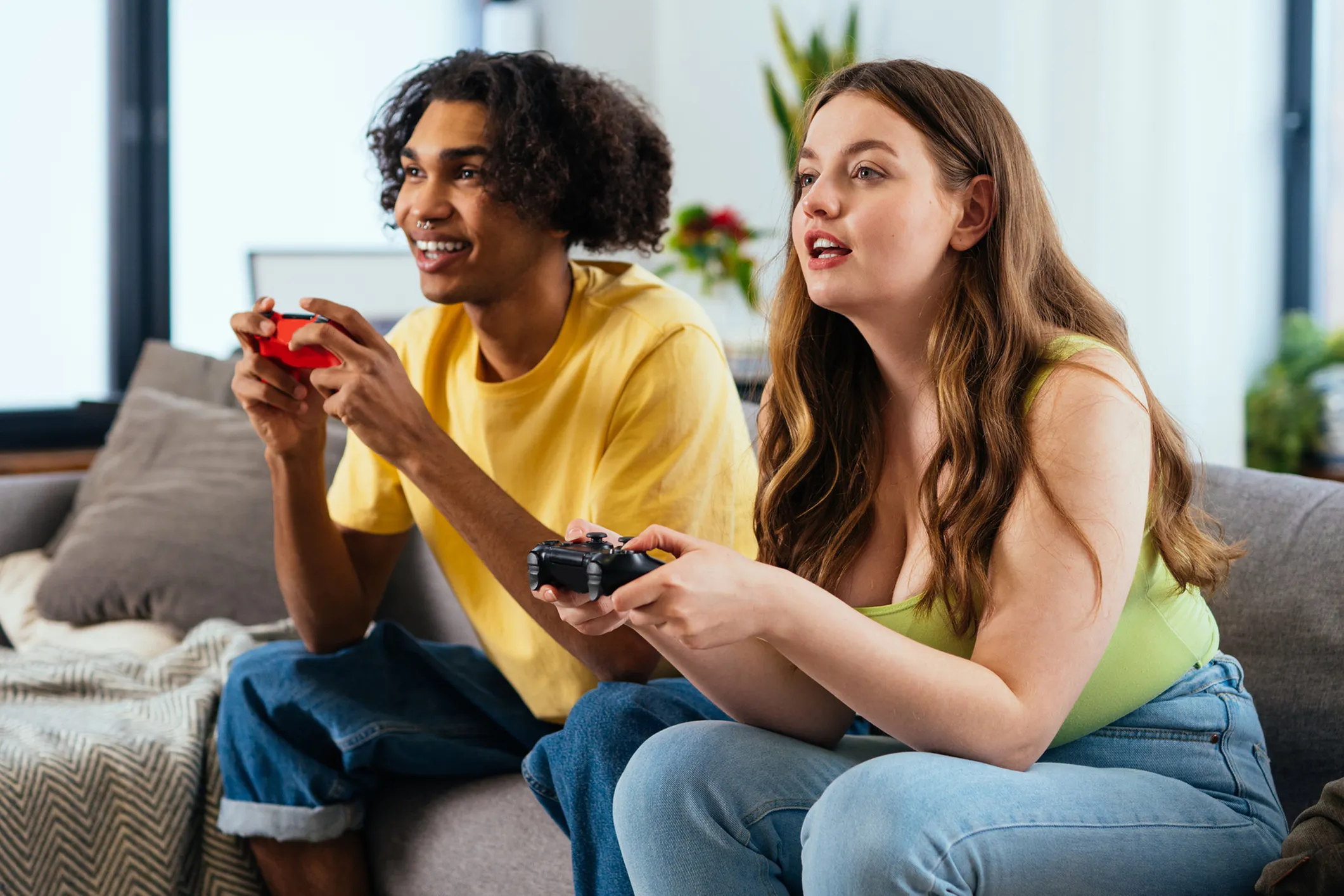 Energetic young adults enjoying video games in a vibrant living room, highlighting a cozy and dynamic space perfect for entertainment.