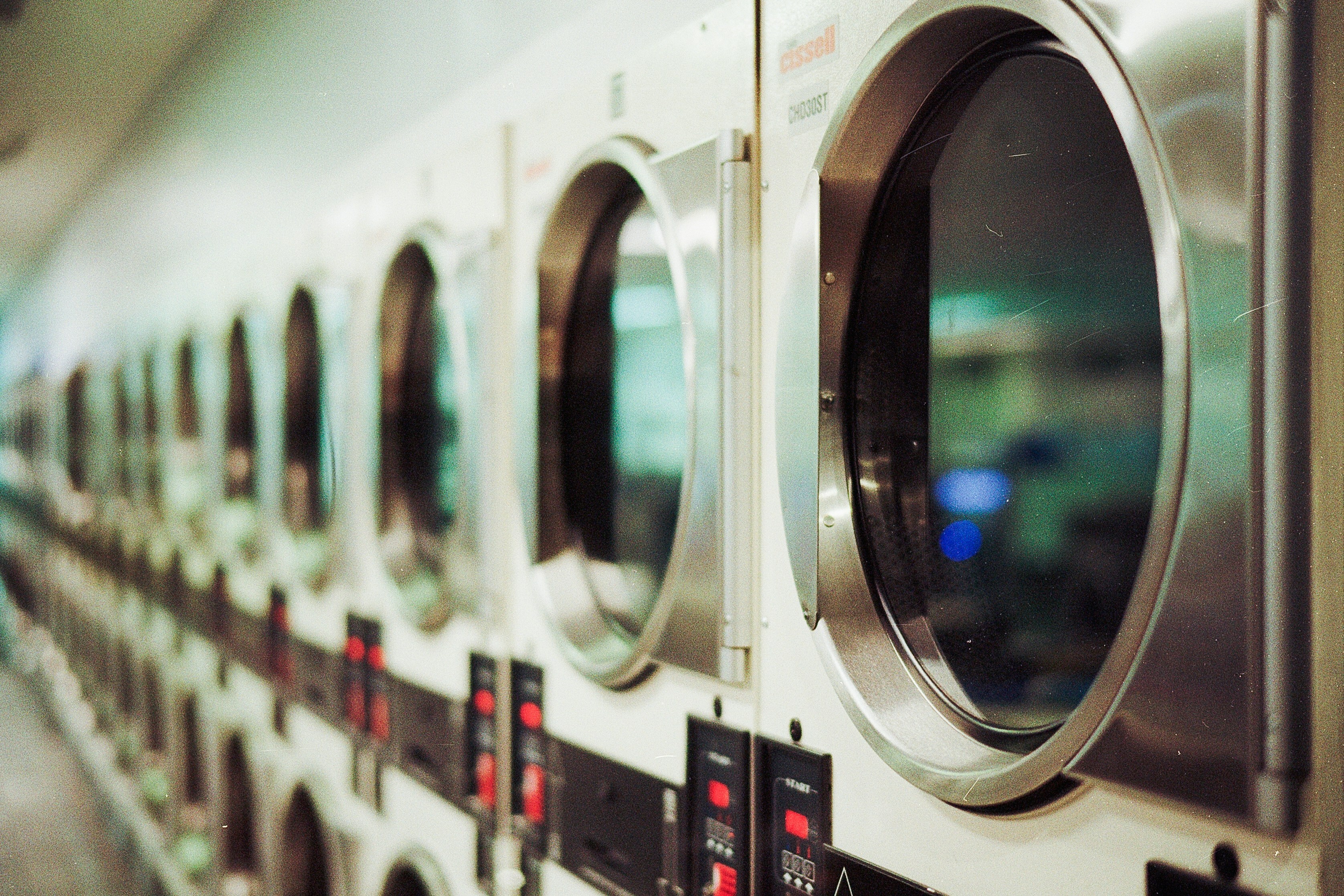 Chic apartment laundry room with a stylish row of modern washers, offering convenience and efficiency for residents.
