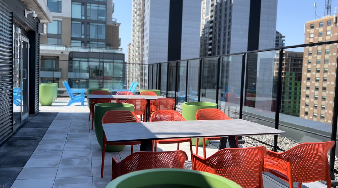 Vibrant rooftop terrace with modern furniture, offering stunning city views and upscale outdoor ambiance.