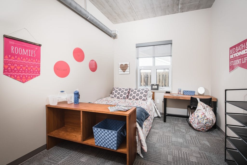 Charming student bedroom with cozy bed, stylish decor, and ample workspace, perfect for comfortable living and studying.
