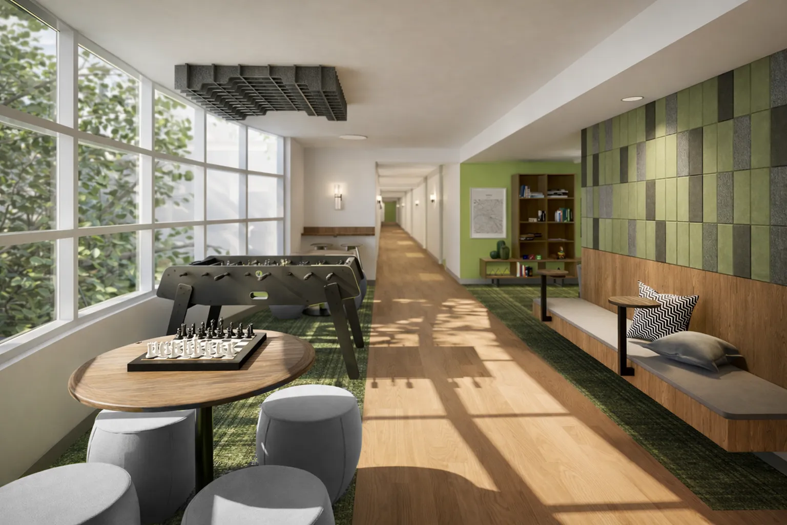 Inviting modern lounge area with large windows, foosball table, and cozy seating, ideal for relaxation and socializing.