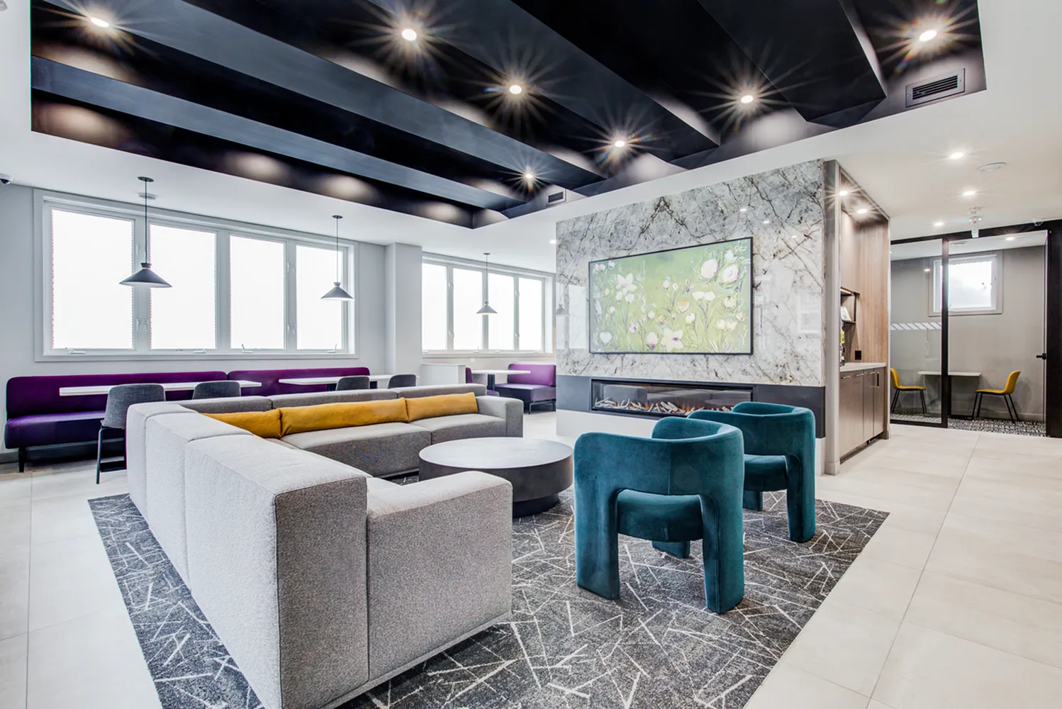 Elegant modern lounge with stylish seating, artistic decor, and ample natural light.
