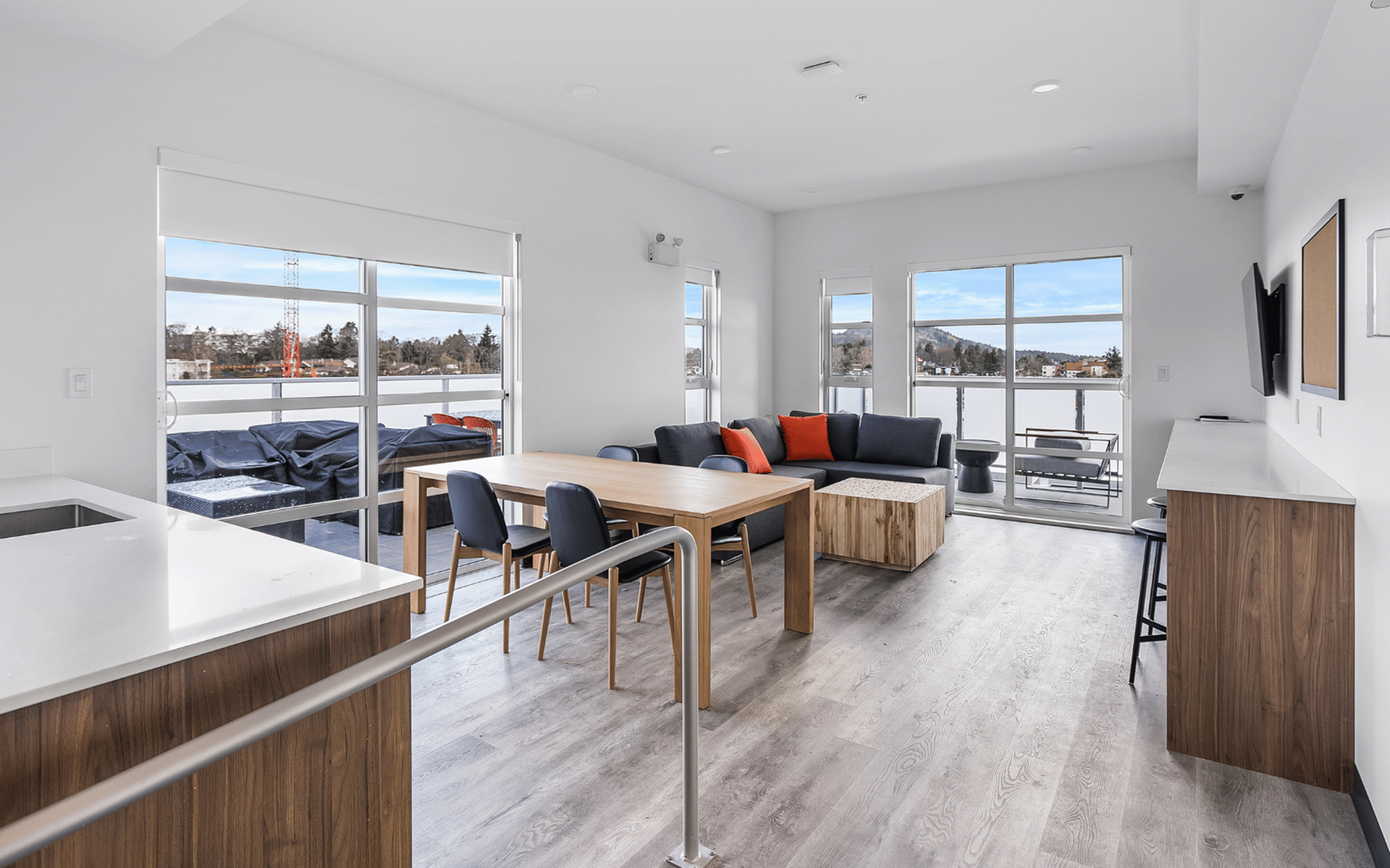 Bright and airy open-concept living and dining area with modern furniture, large windows, and a stunning view.
