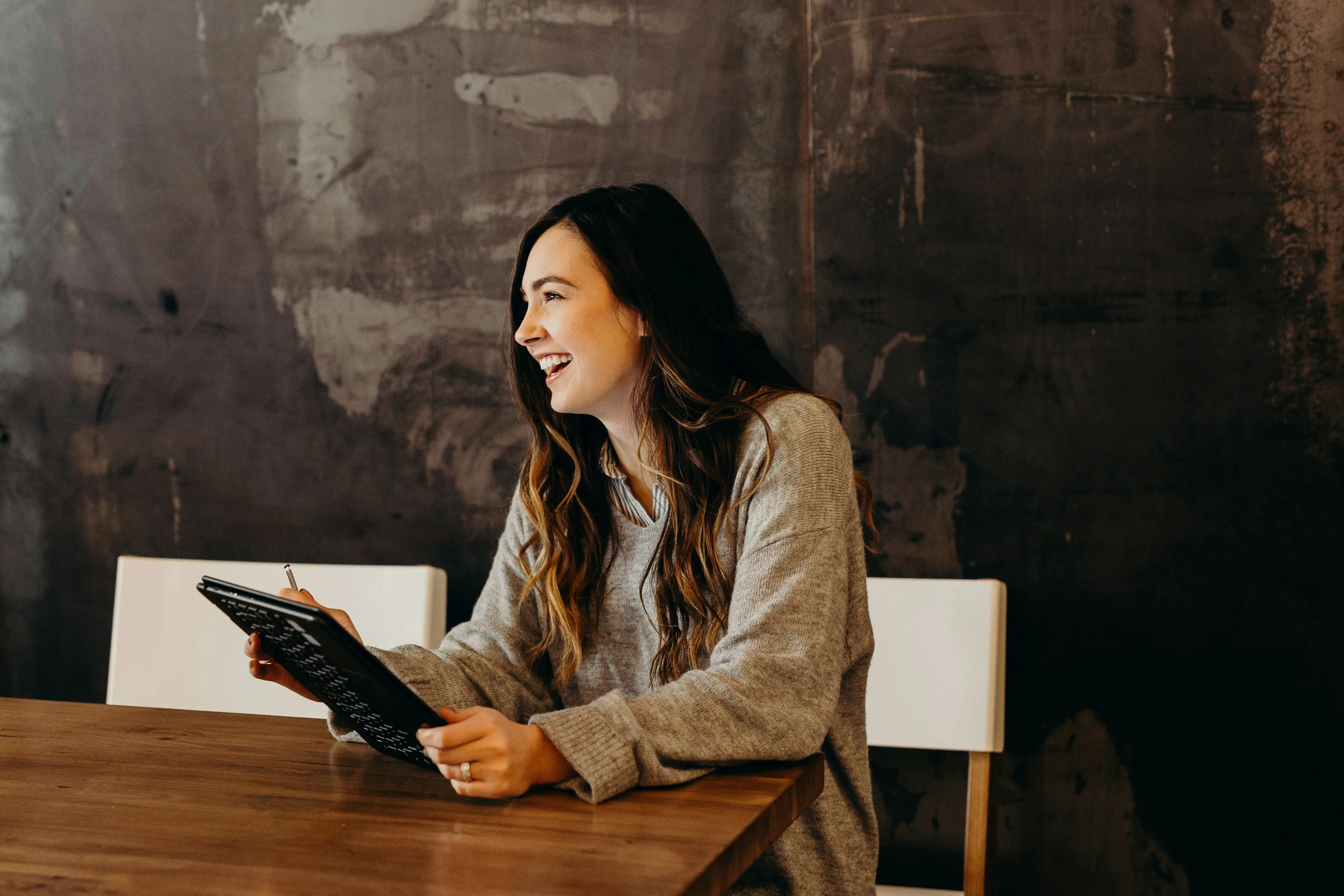 Bright and inviting office space showcasing a smiling professional woman in casual attire, bringing warmth and creativity to the working environment.