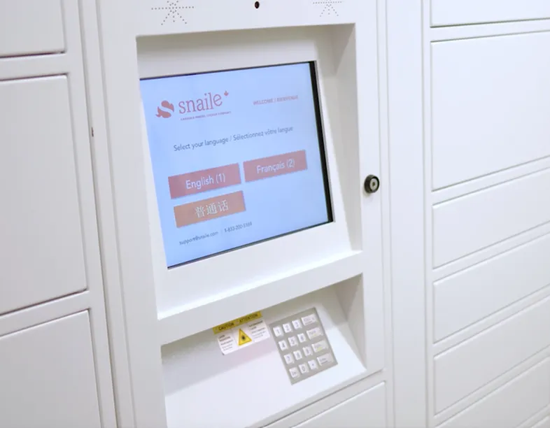 Modern apartment lobby with a sleek parcel locker system featuring a digital touch screen interface for language selection.