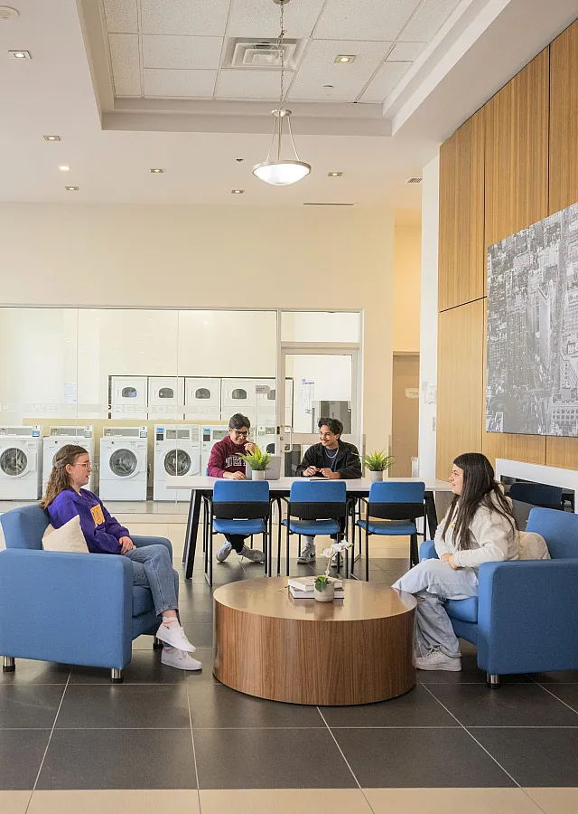 Vibrant communal area with modern seating, vending machines, and a large laundry facility, perfect for socializing and relaxation.