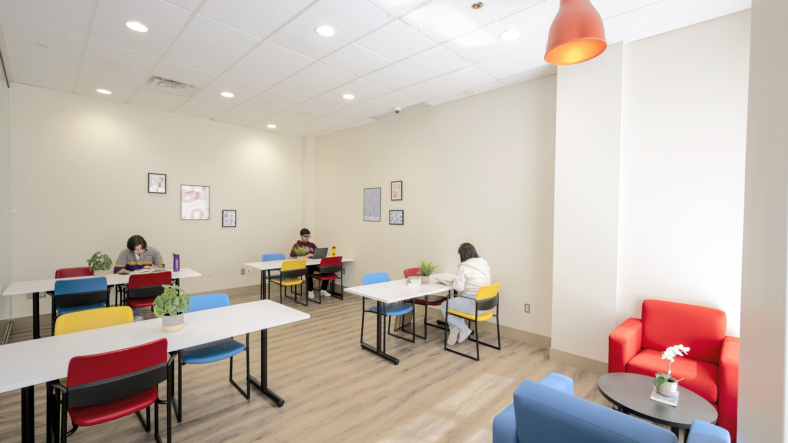 Bright and modern study area with colorful chairs and cozy seating, perfect for focused work or collaboration.