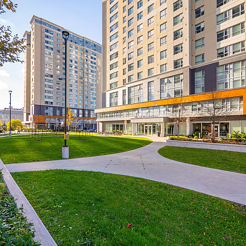 Modern high-rise apartment buildings with expansive green courtyard, offering a serene urban living environment.