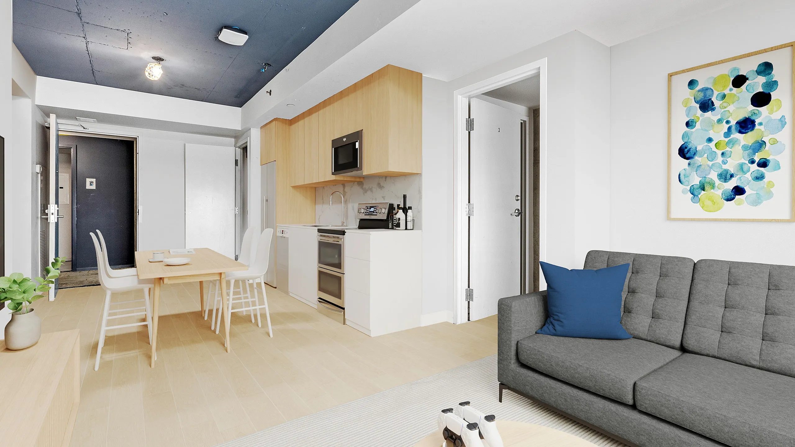 Modern open-plan living space with minimalist design, featuring a sleek kitchen with wooden accents, a cozy dining area, and a comfortable gray sofa with colorful wall art.