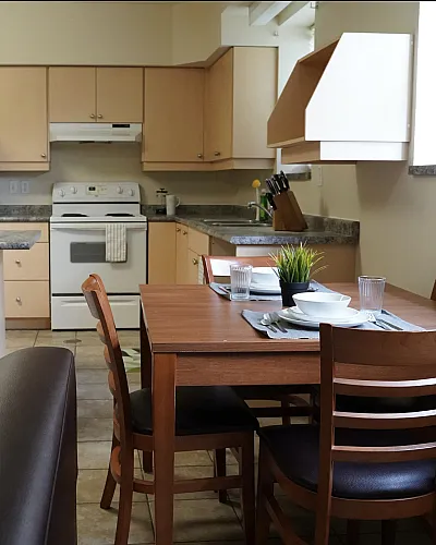 Inviting kitchen and dining area featuring modern appliances, sleek countertops, and cozy wooden furniture.
