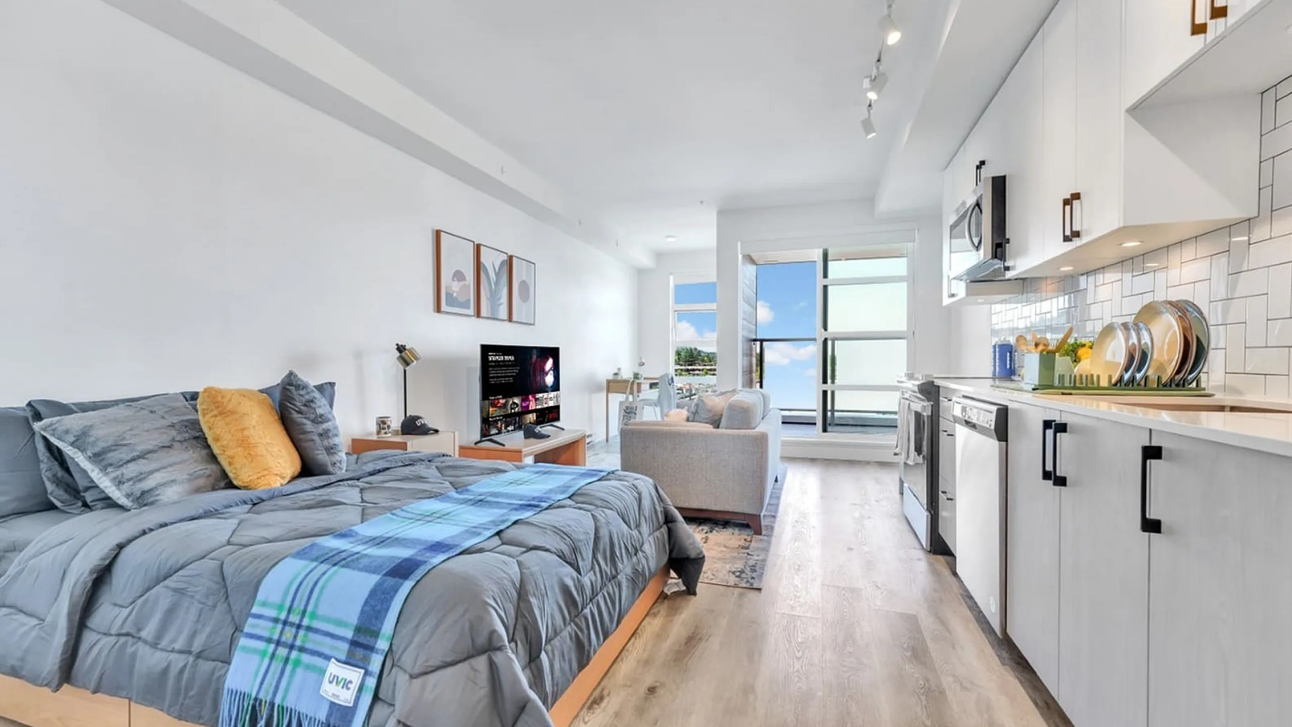Modern studio apartment with open-concept layout, featuring a cozy sleeping area, sleek kitchen, and bright living room with large windows offering stunning views.