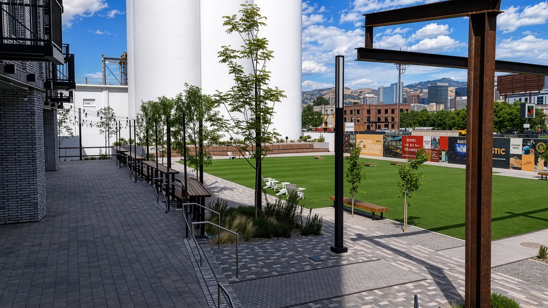 Silo Park at sunset with open green space, outdoor seating, and views toward downtown Salt Lake City and the mountains.