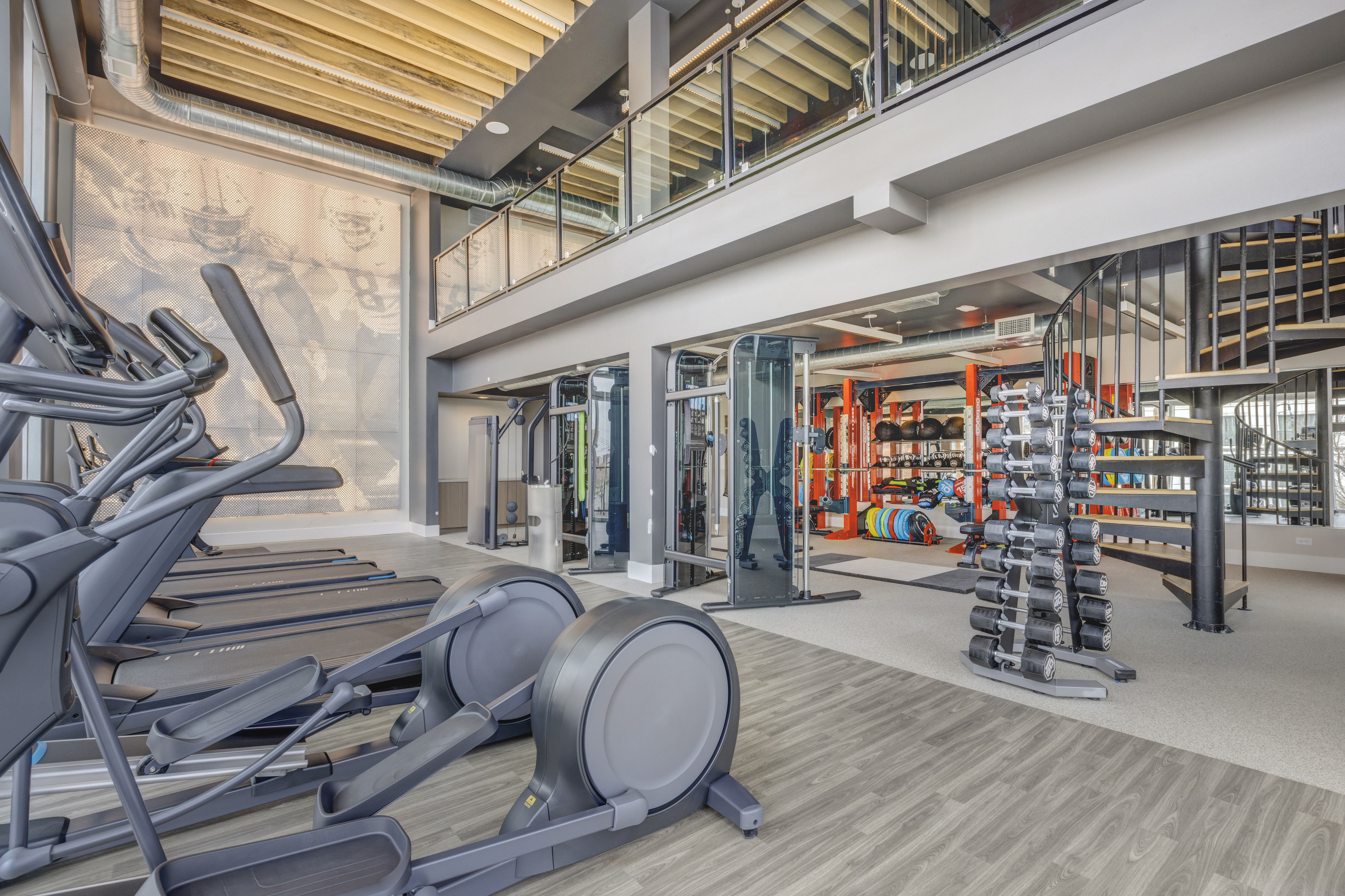 Two-story fitness center at 6th & Main Apartments in downtown Salt Lake City featuring cardio equipment, free weights, strength training, and modern finishes.