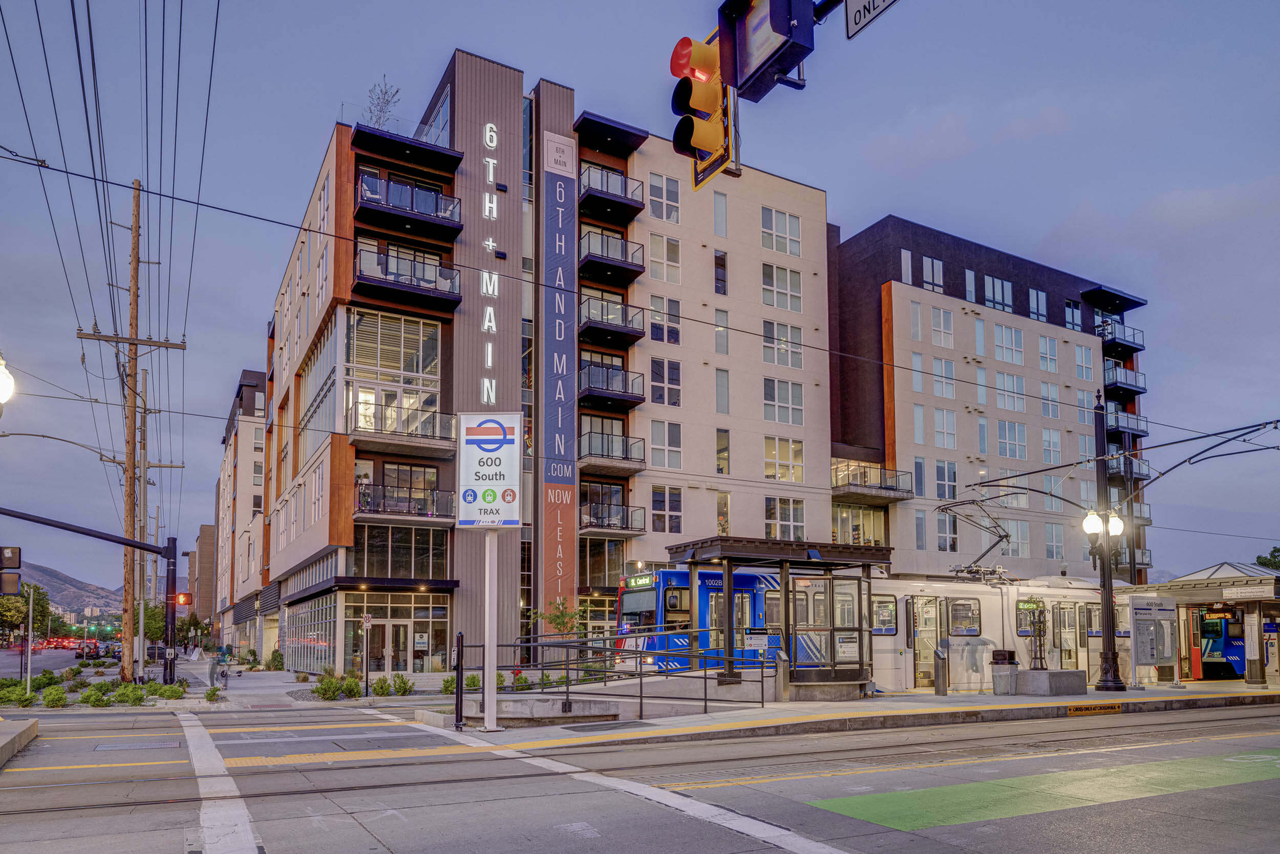 Exterior of 6th & Main Apartments in downtown Salt Lake City with UTA TRAX station directly outside the community entrance.