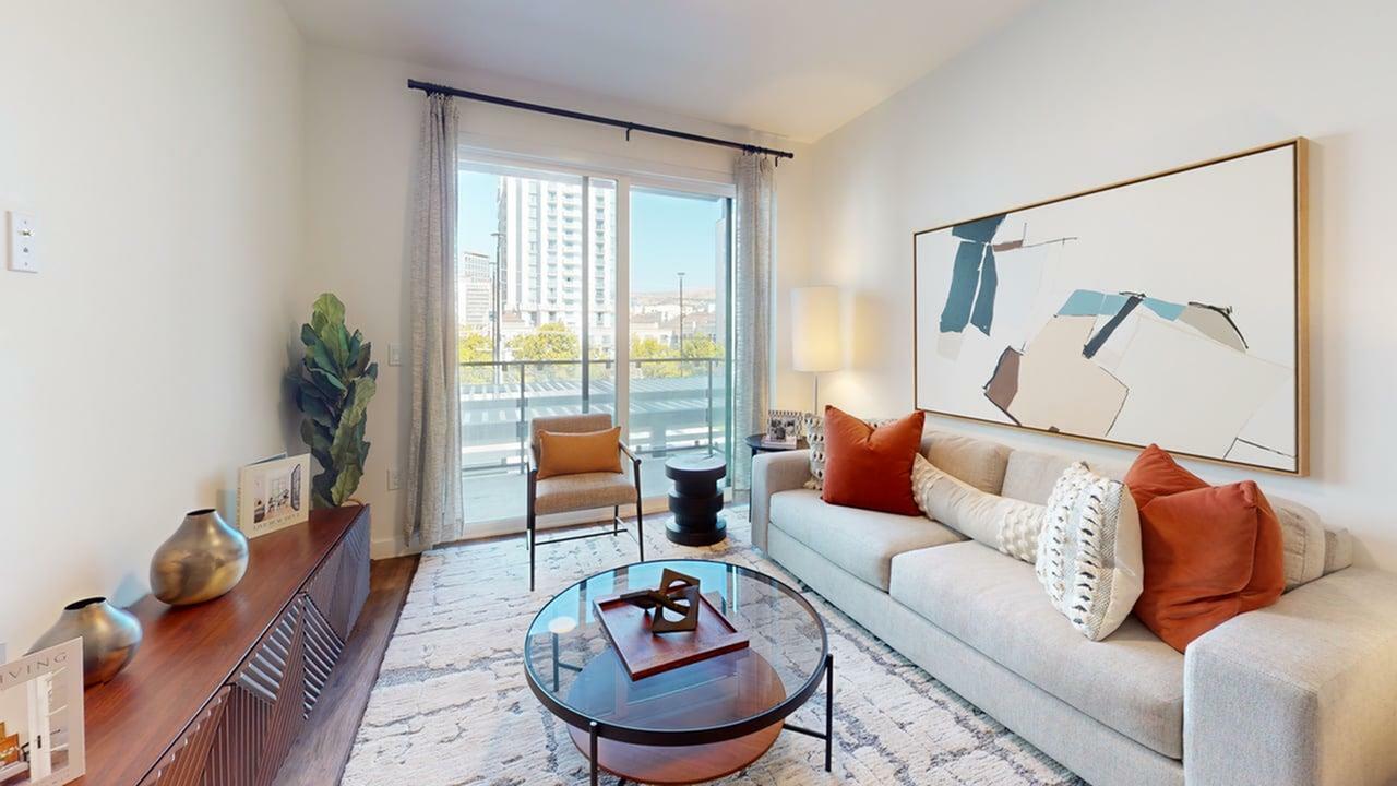 Modern open-concept living room at 6th & Main Apartments in downtown Salt Lake City featuring natural light, designer finishes, and private balcony access.