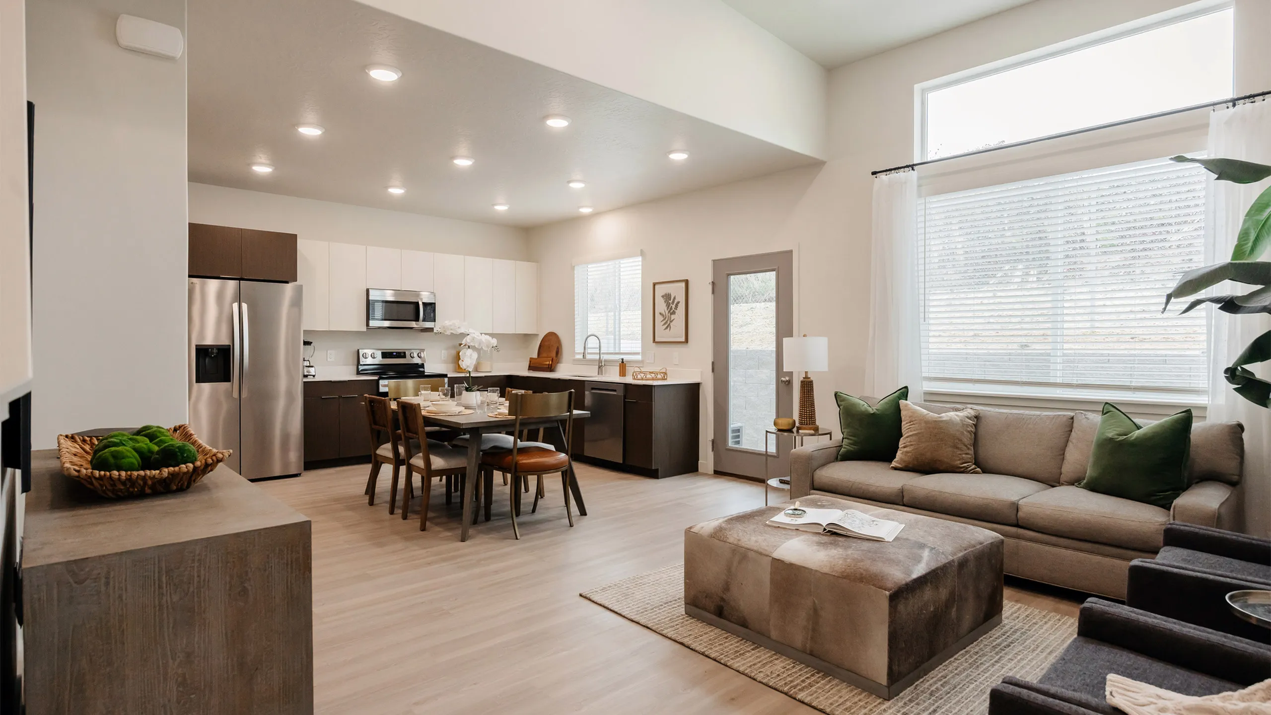 Cozy Timberline family room featuring sofa, chairs, and modern d&eacute;cor in Railrunner Townhomes Roy Utah