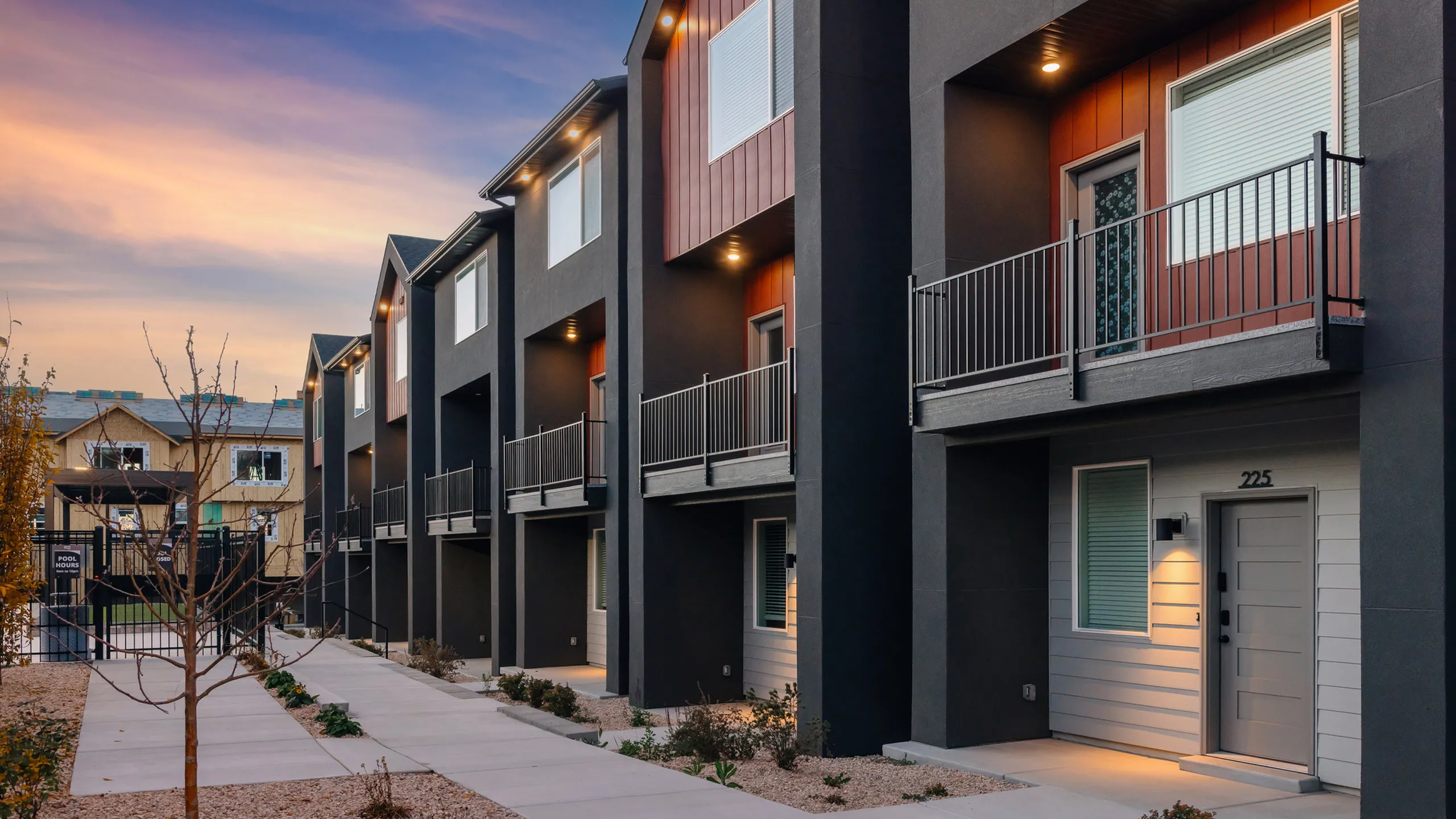 Contemporary townhome exteriors with private entries and balconies at RailRunner Townhomes in Roy, Utah.