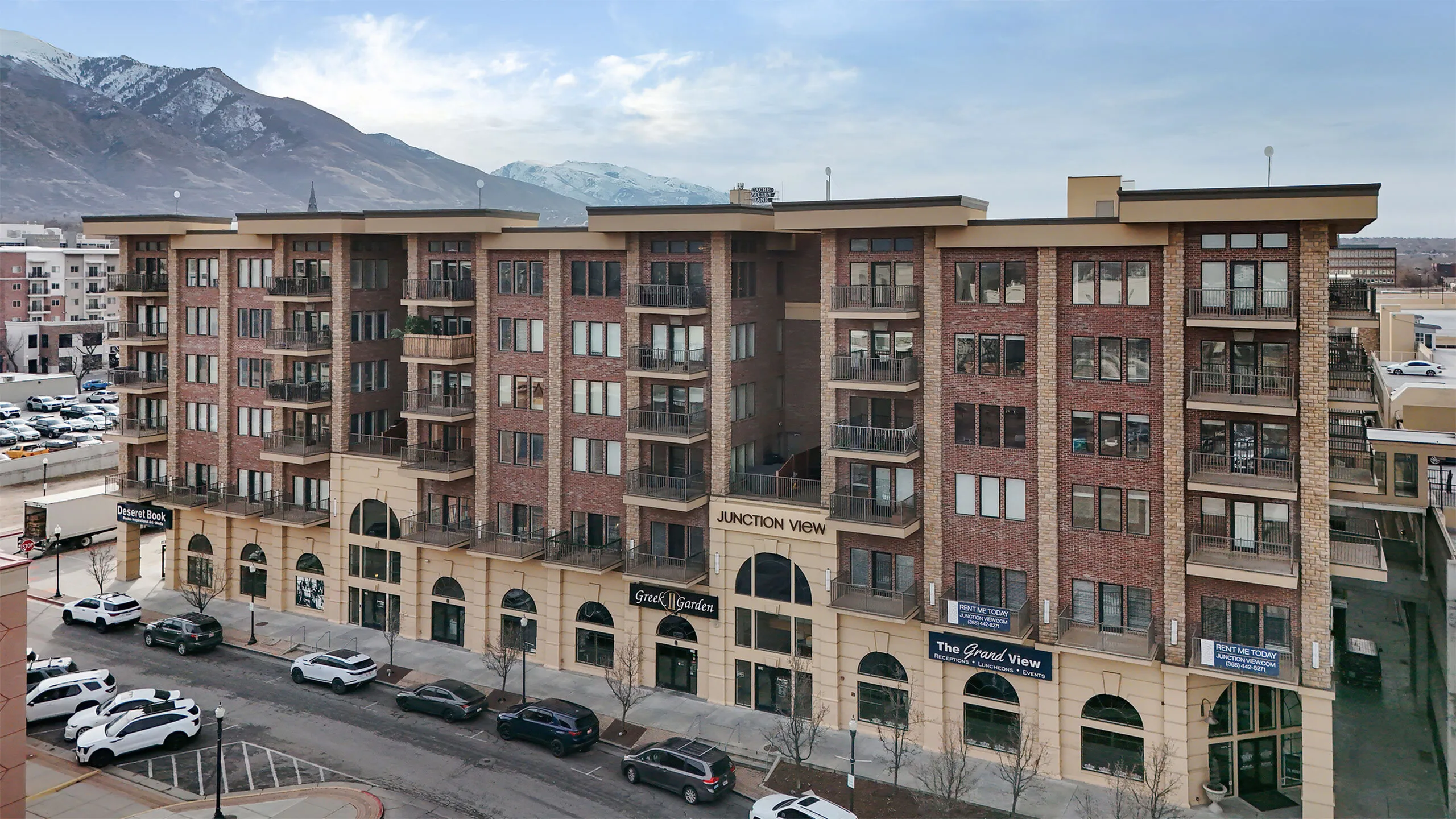 Exterior view of Junction View Apartments in Ogden, Utah featuring brick architecture, private balconies, and scenic Wasatch Mountain views.