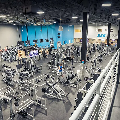 Interior of EōS Fitness Ogden gym with cardio equipment and free weights, located next to Junction View apartments with included memberships