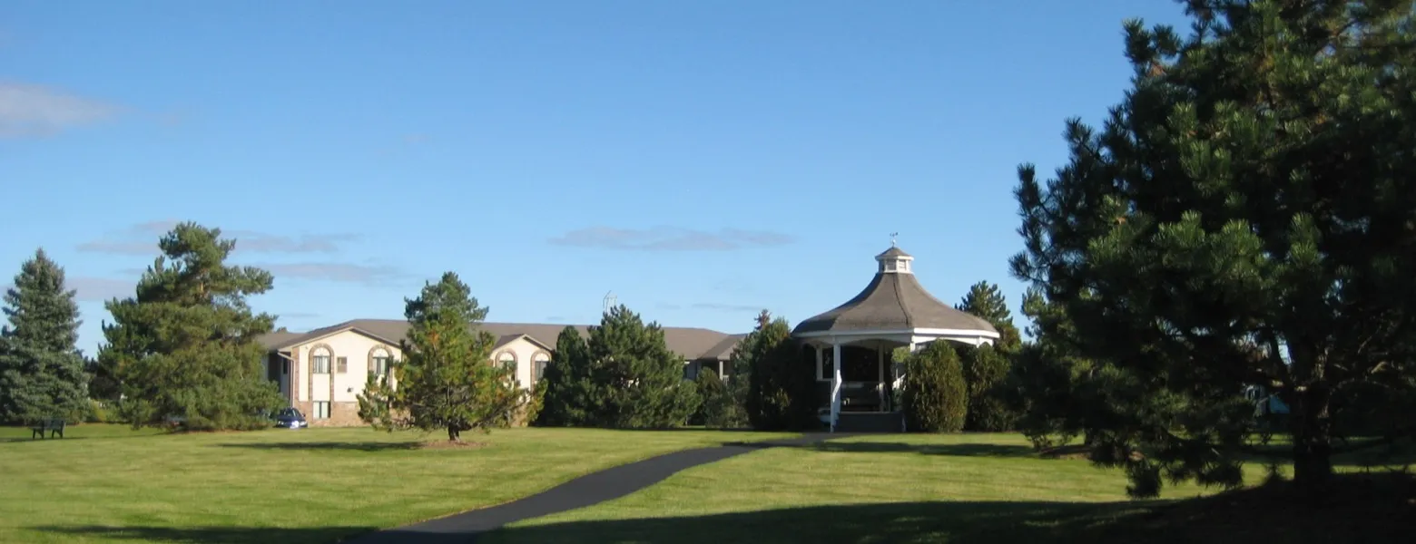 Property image featuring gazebo surrounded by trees. Community building visible in the distance.