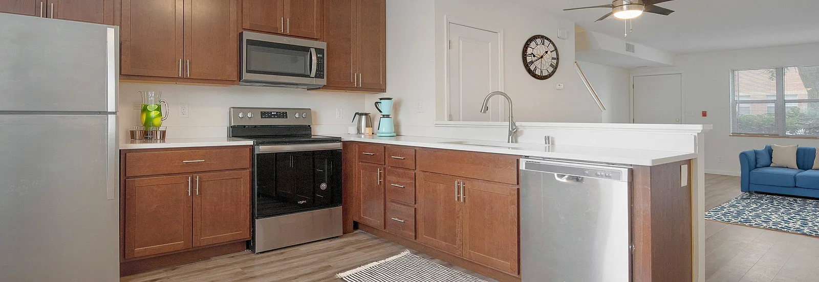 Modern kitchen with stainless steel appliances, elegant cabinetry, and spacious open-concept living area with stylish decor.