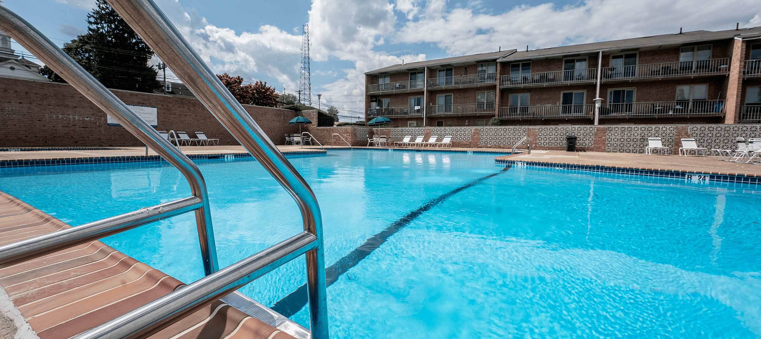 Outdoor pool area at Woodmere Apartments