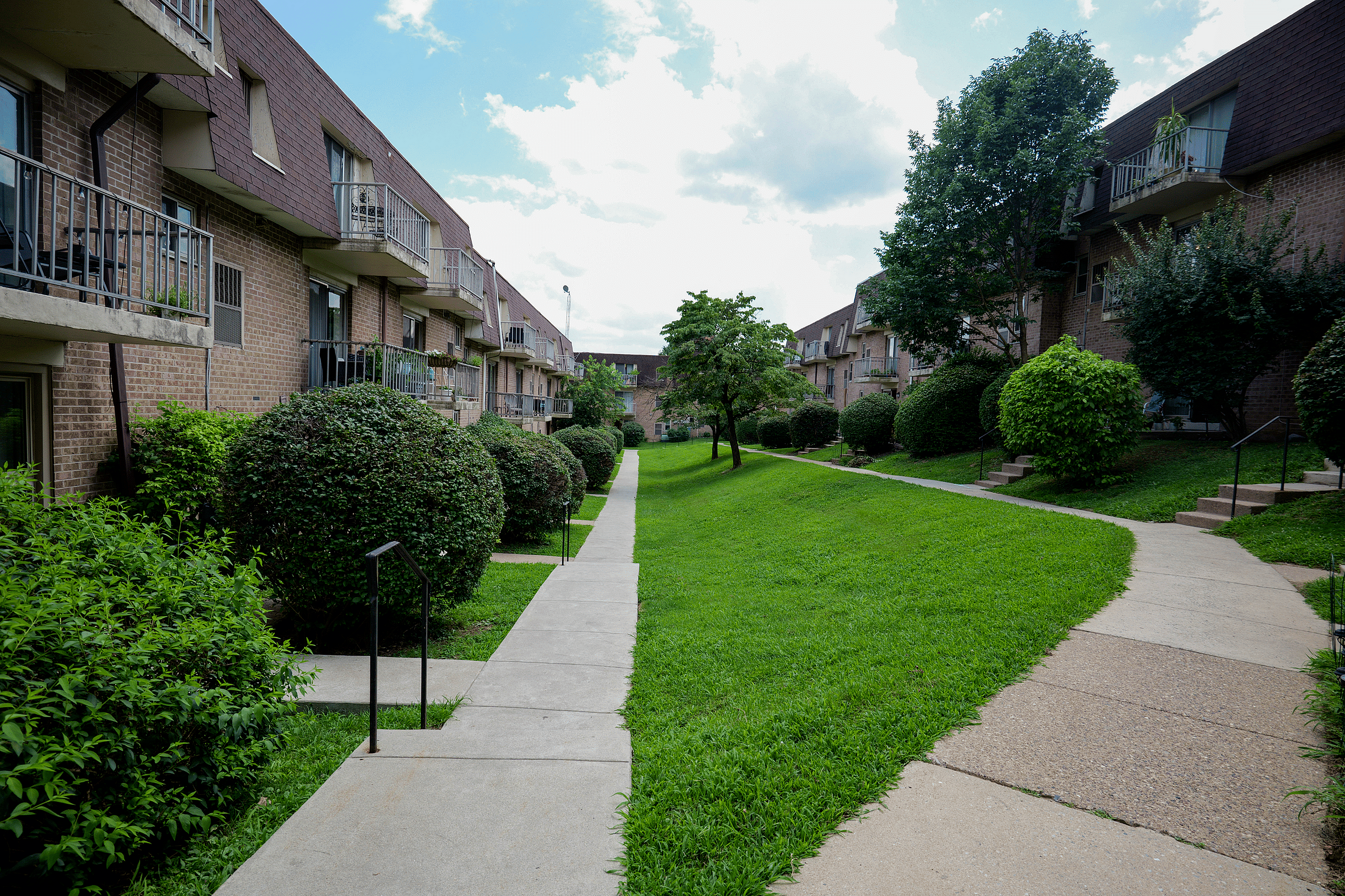 Peaceful green space surrounding Valley High Apartments with walking paths and mature trees