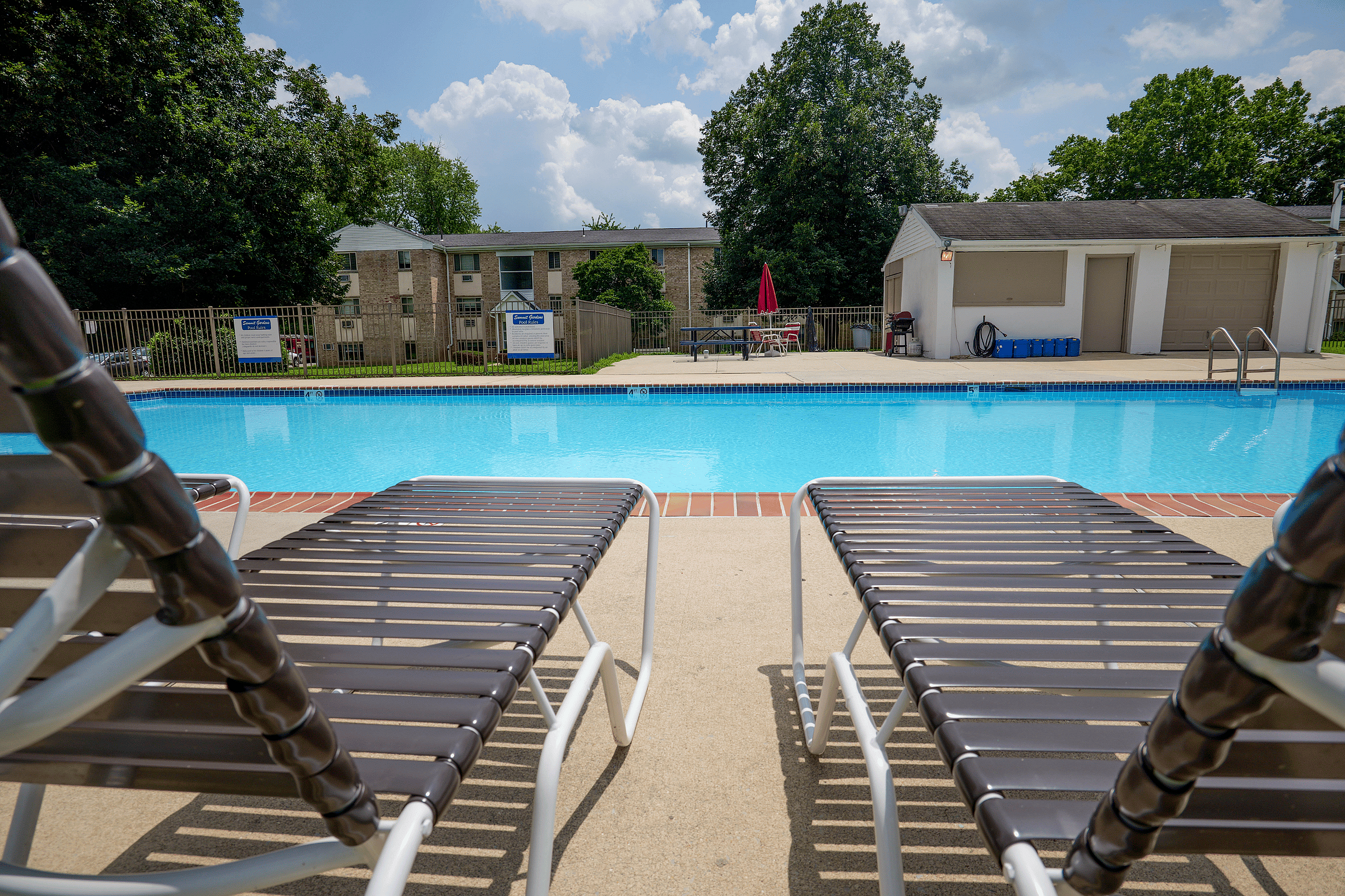 Inviting outdoor pool area with comfortable lounge chairs, perfect for relaxation and enjoyment on sunny days.
