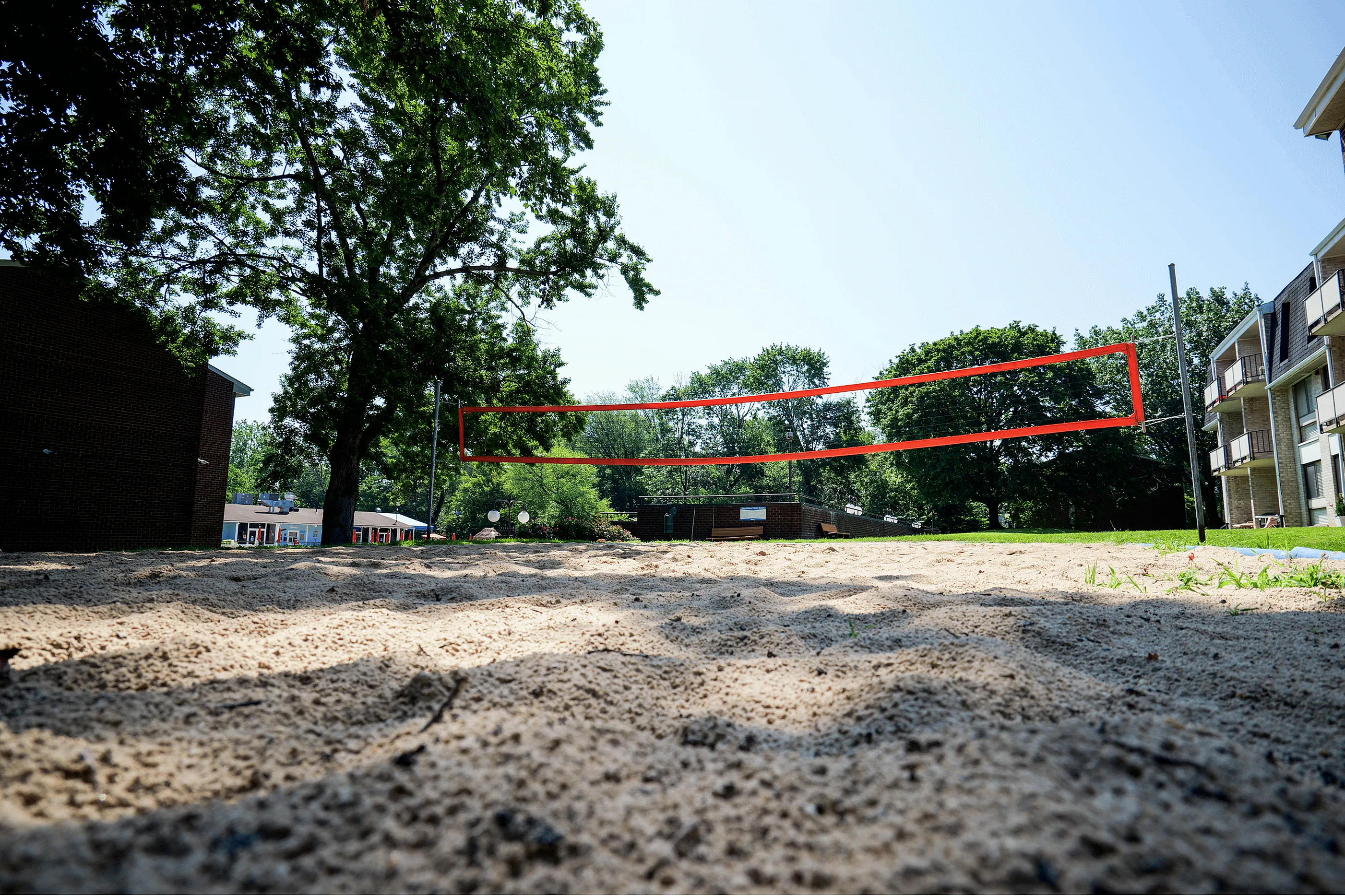 Inviting outdoor sand volleyball court surrounded by lush greenery, perfect for recreational activities and relaxation.