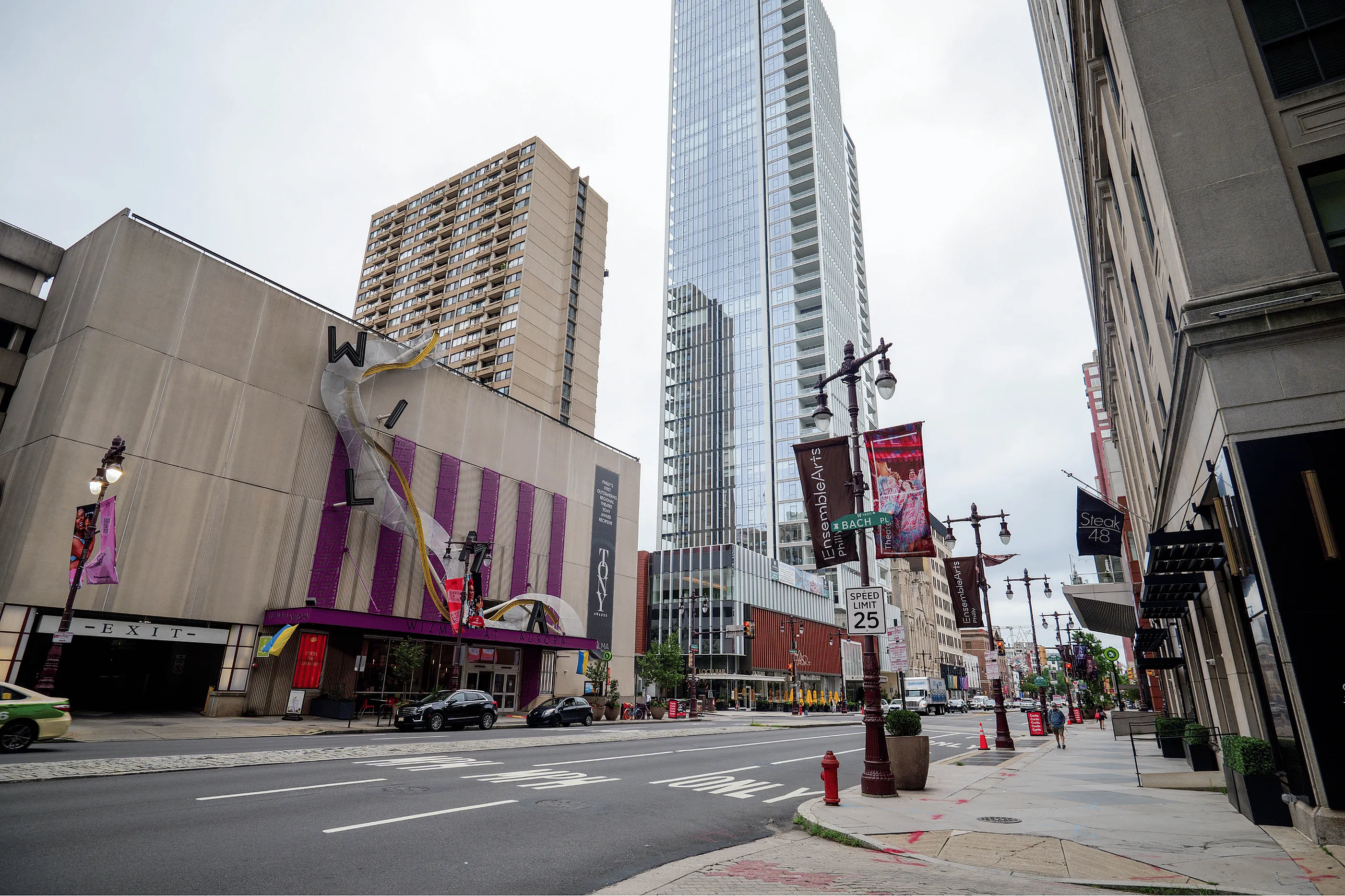 Vibrant urban scene with modern high-rise buildings, colorful art installations, and bustling city street ambiance.