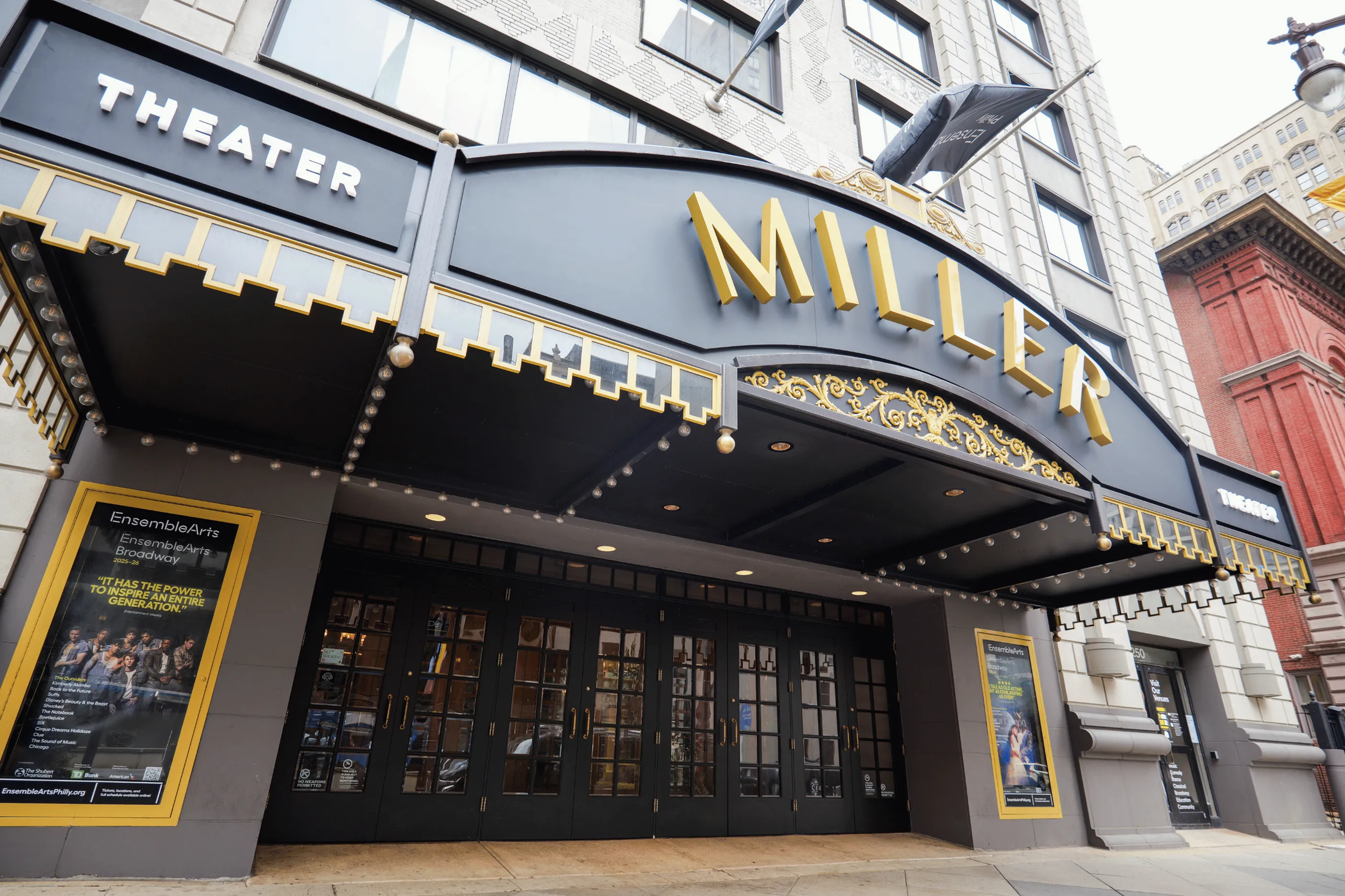 Elegant theater entrance with prominent marquee and stylish architectural details, inviting patrons to an exciting cultural experience.